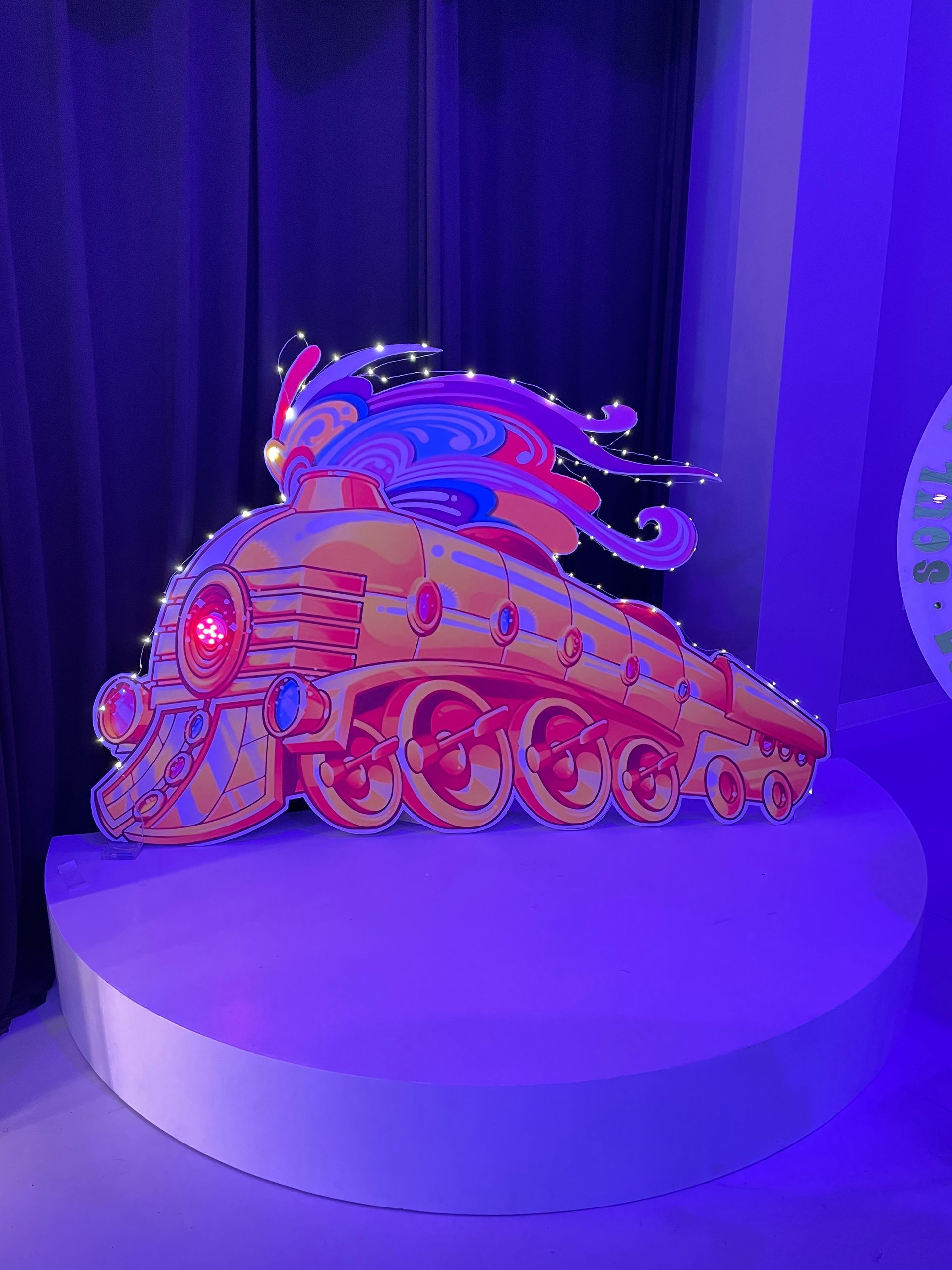 Purple lit stage backdrop with themed event décor and illuminated display elements