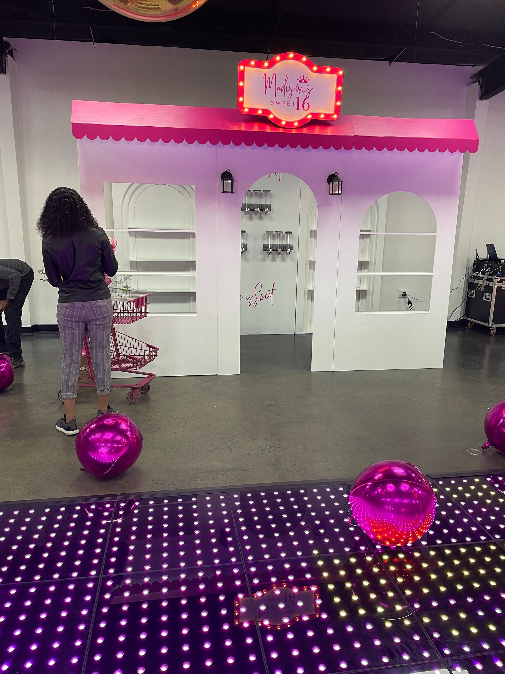 Pink boutique storefront prop rental with marquee sign for girls birthday party décor