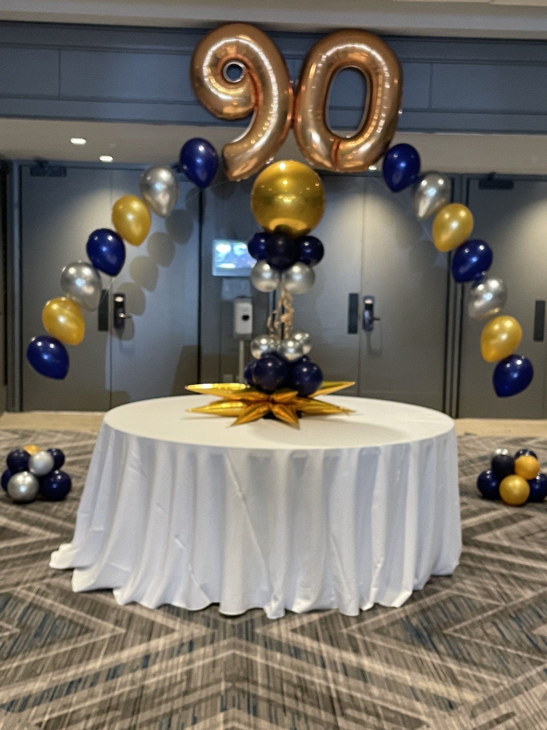 Close-up of gold and navy graduation balloon arch with number 20 balloons