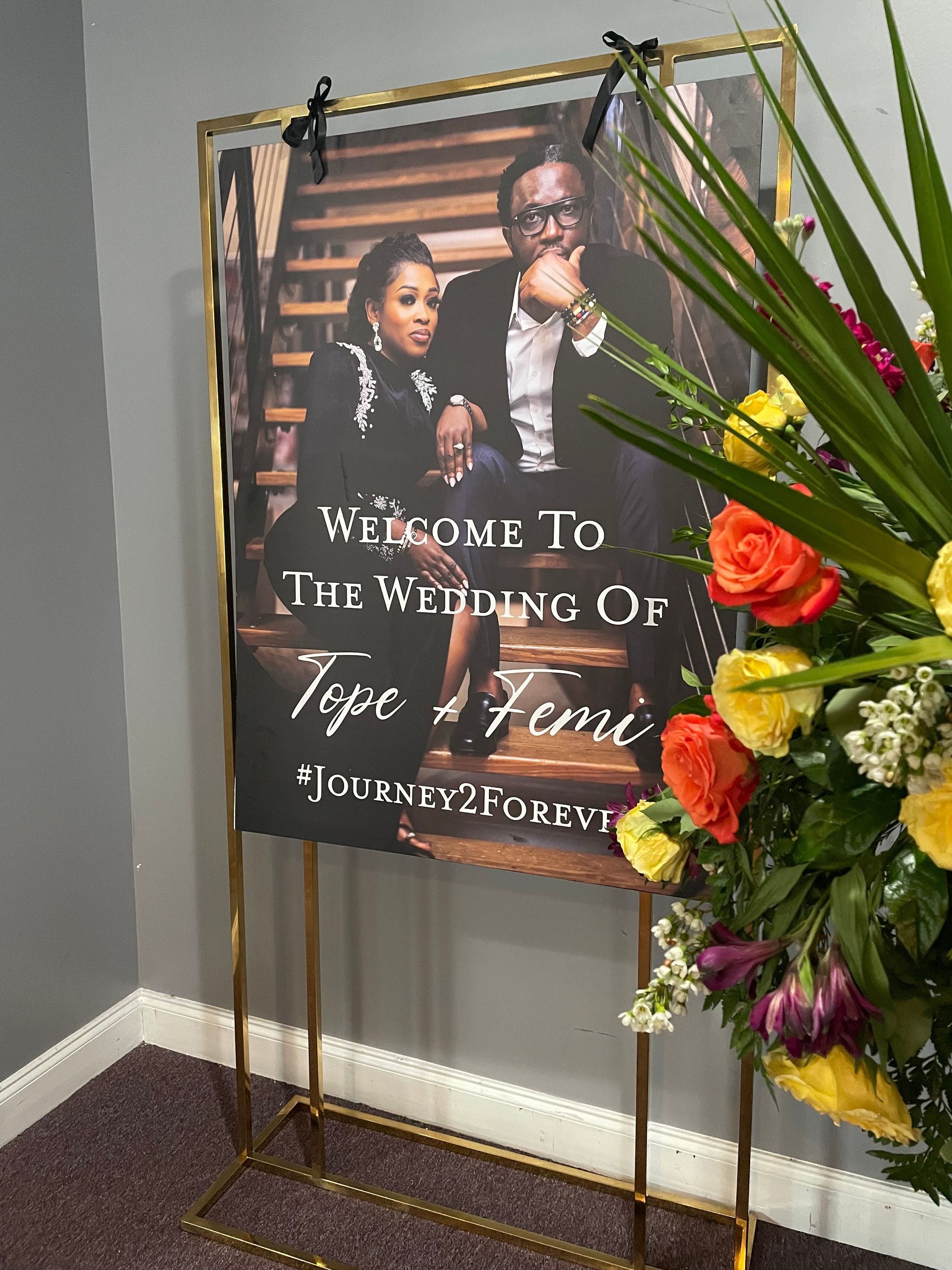 Framed welcome sign with couple portrait and floral accents for wedding or formal event entry display