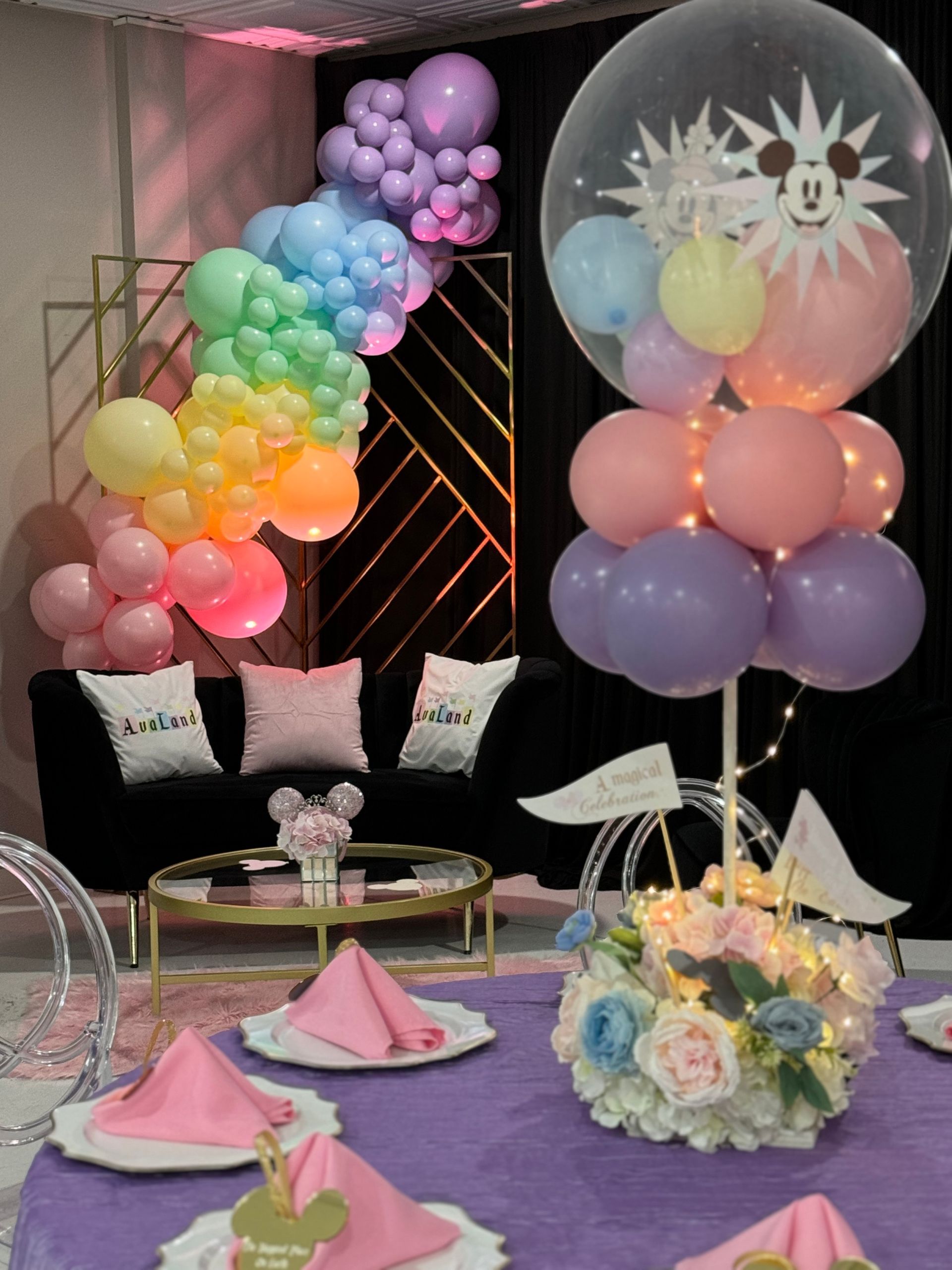 Rainbow balloon garland with oversized clear bubble balloon and soft pastel colors for kids birthday celebration