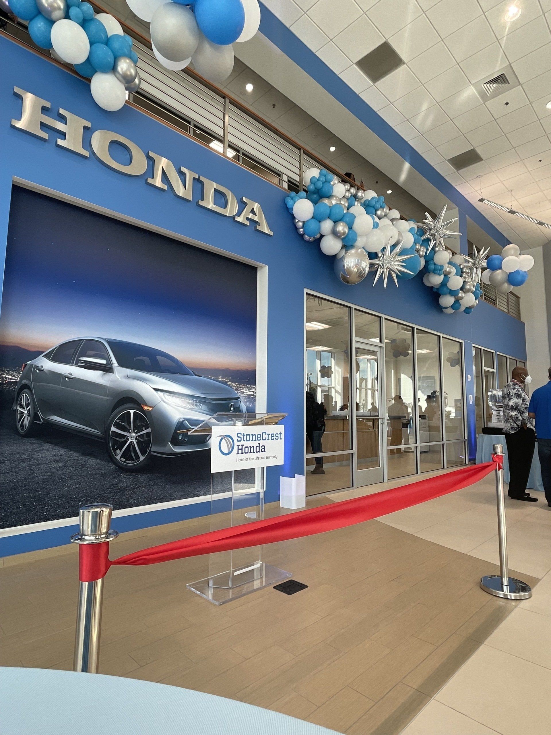 Blue white and silver balloon garland with star accents for automotive dealership or corporate event