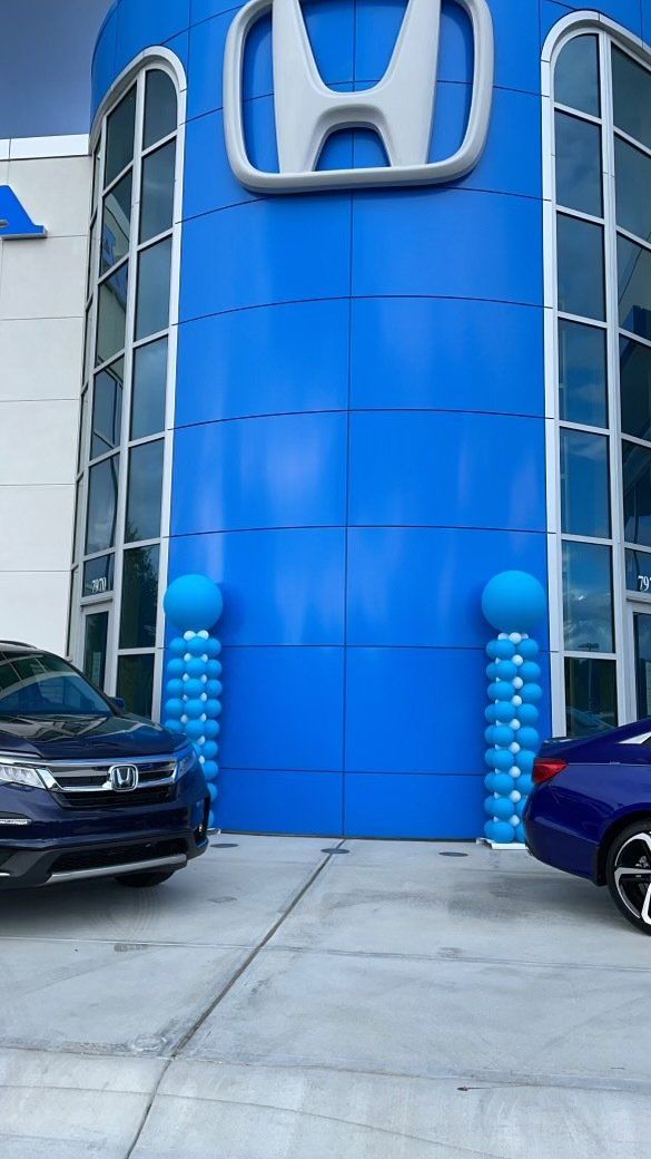 Exterior view of a Honda dealership building with blue architectural signage