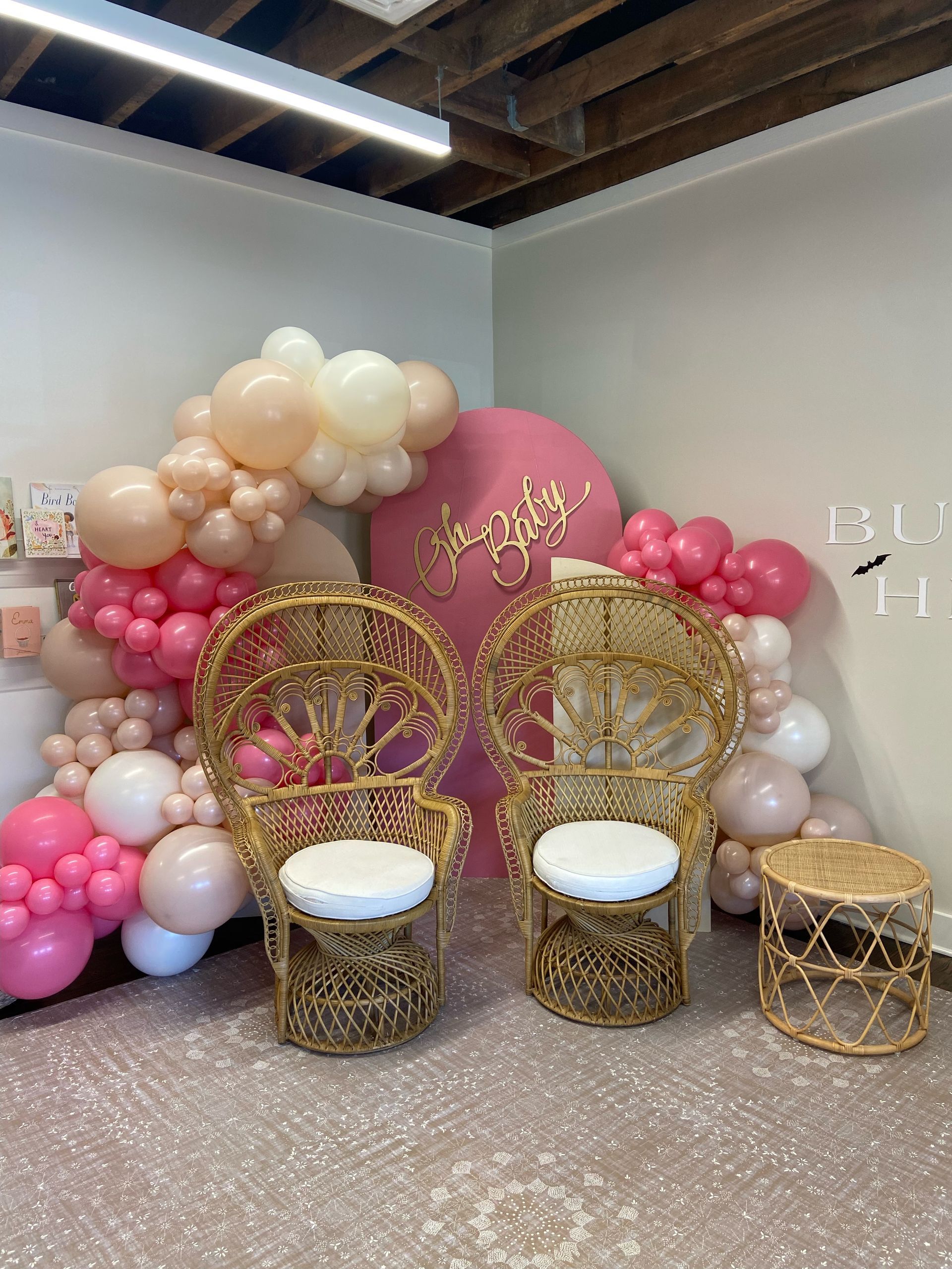 Neutral beige and blush organic balloon garland with round pink backdrop for modern birthday celebration