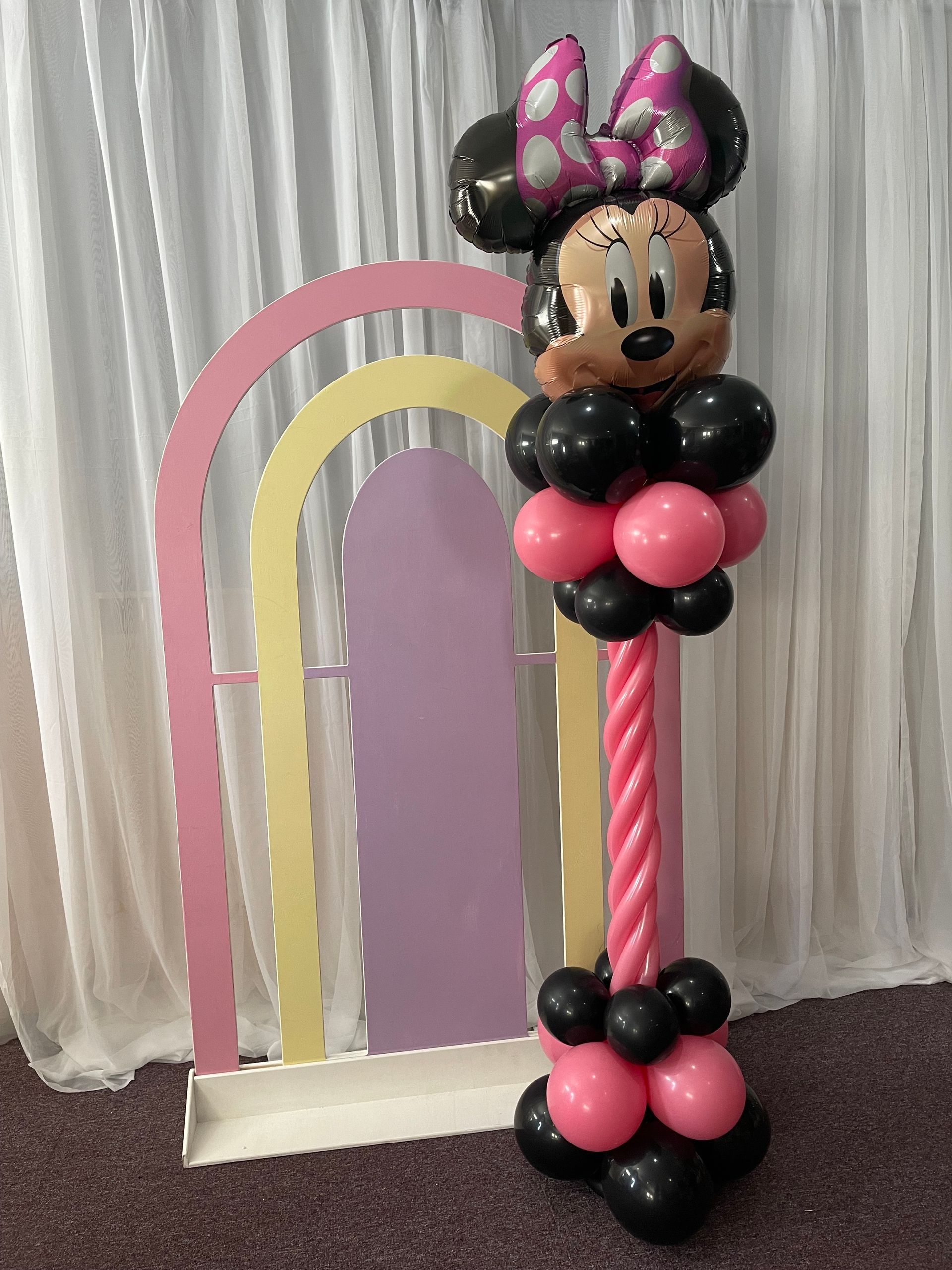 Minnie Mouse–themed balloon sculpture with pink and black balloons for a children’s party