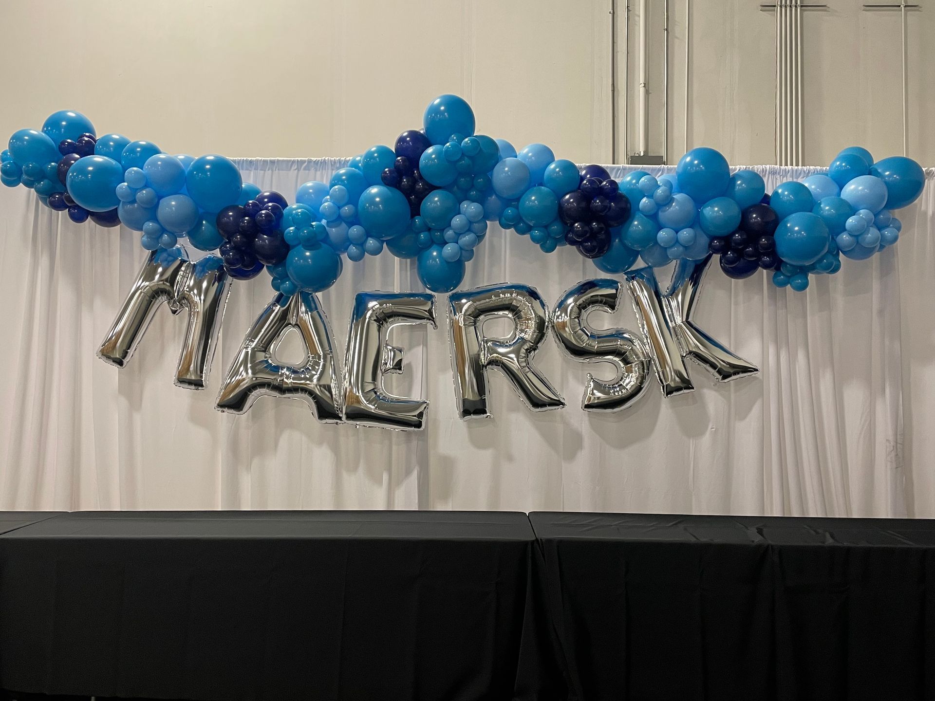 Blue balloon garland with silver letter balloons spelling name for birthday party backdrop décor
