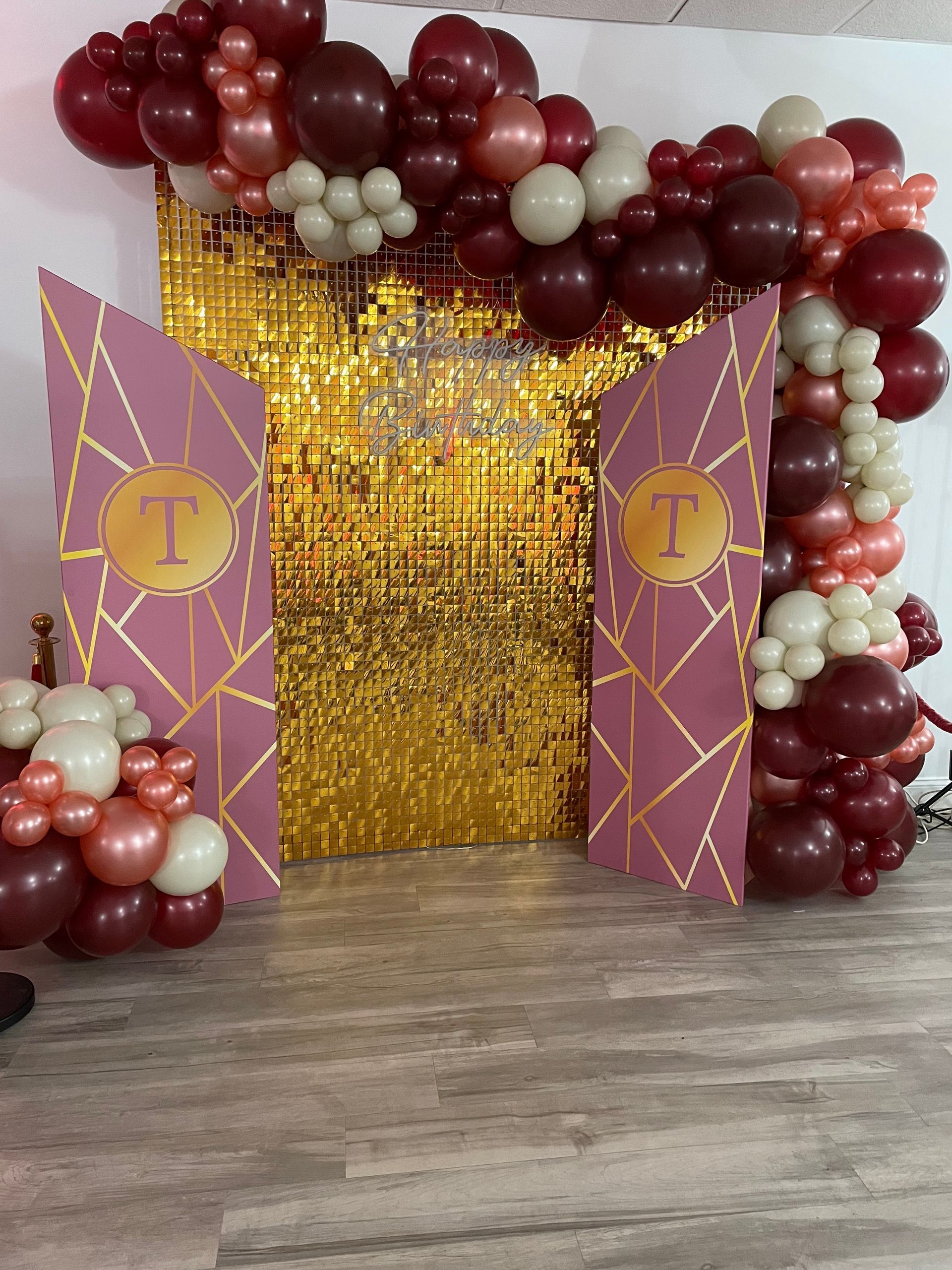 Burgundy cream and gold balloon garland with gold sequin backdrop for formal themed event