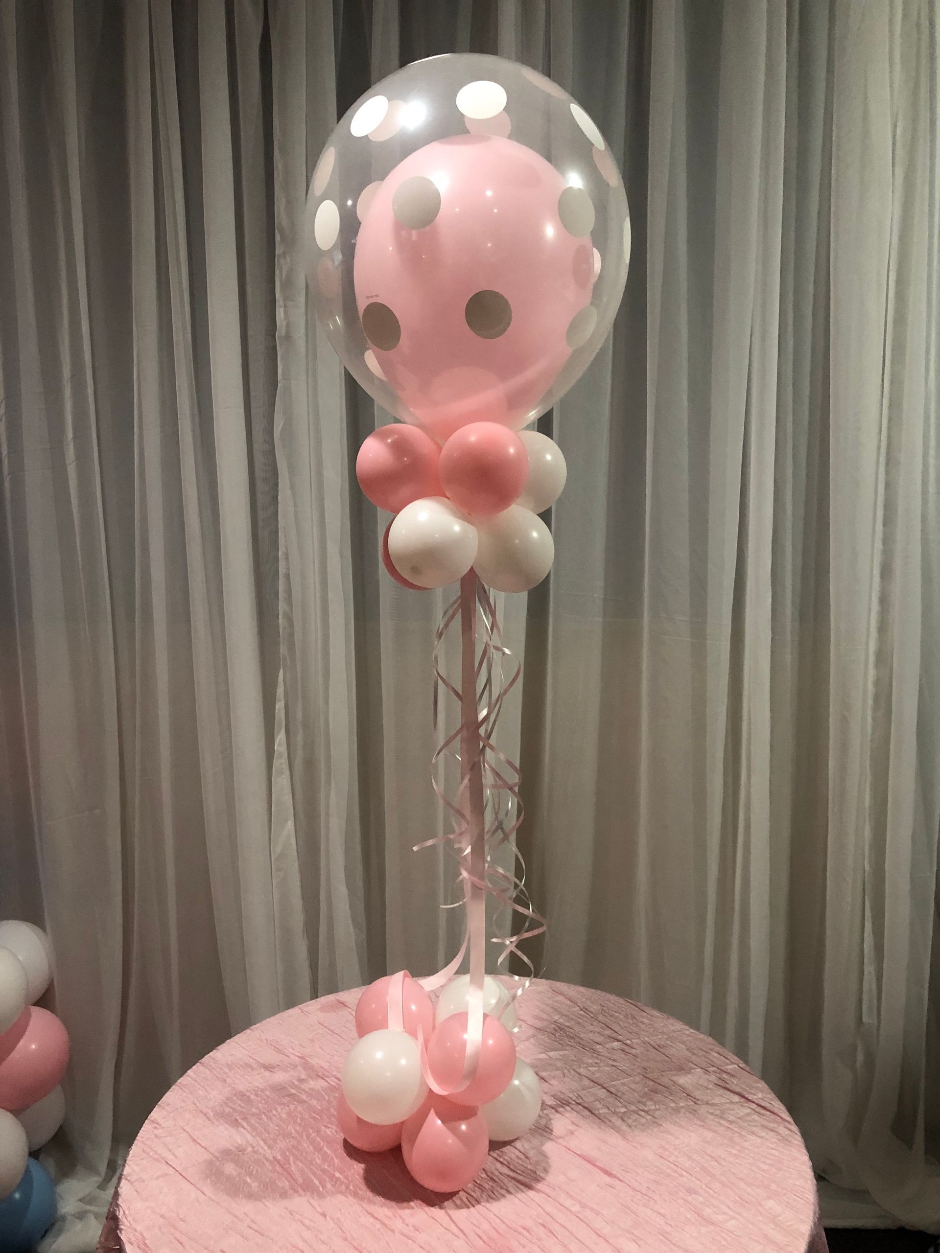 Clear bubble balloon with pink balloons inside and base cluster for baby shower or birthday party decoration