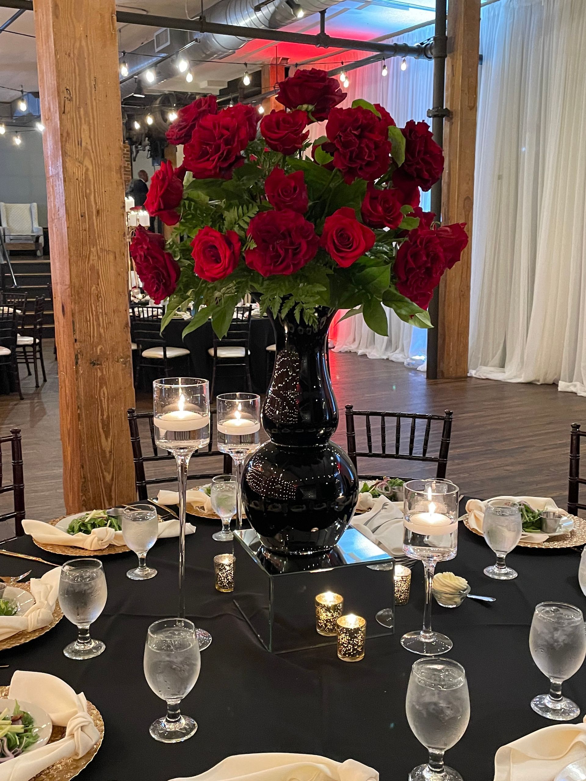 Large red rose floral arrangement displayed indoors for event décor