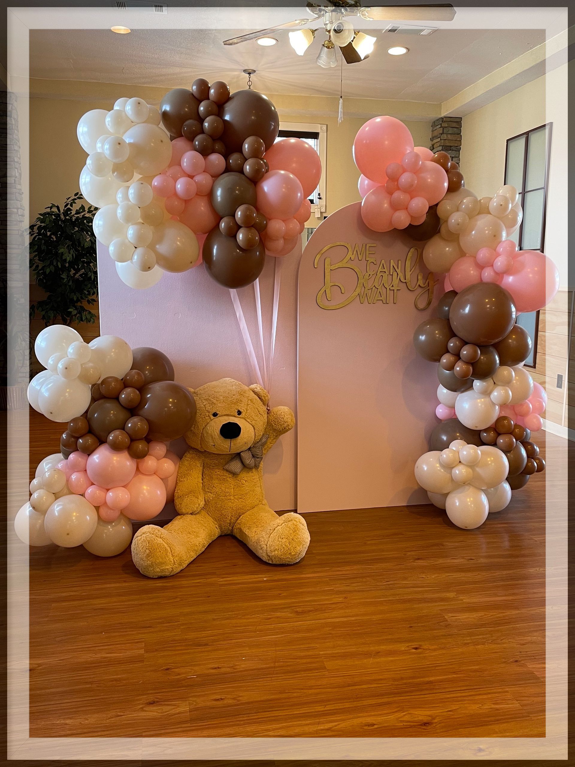 Blush peach and brown organic balloon clusters around custom baby shower backdrop display