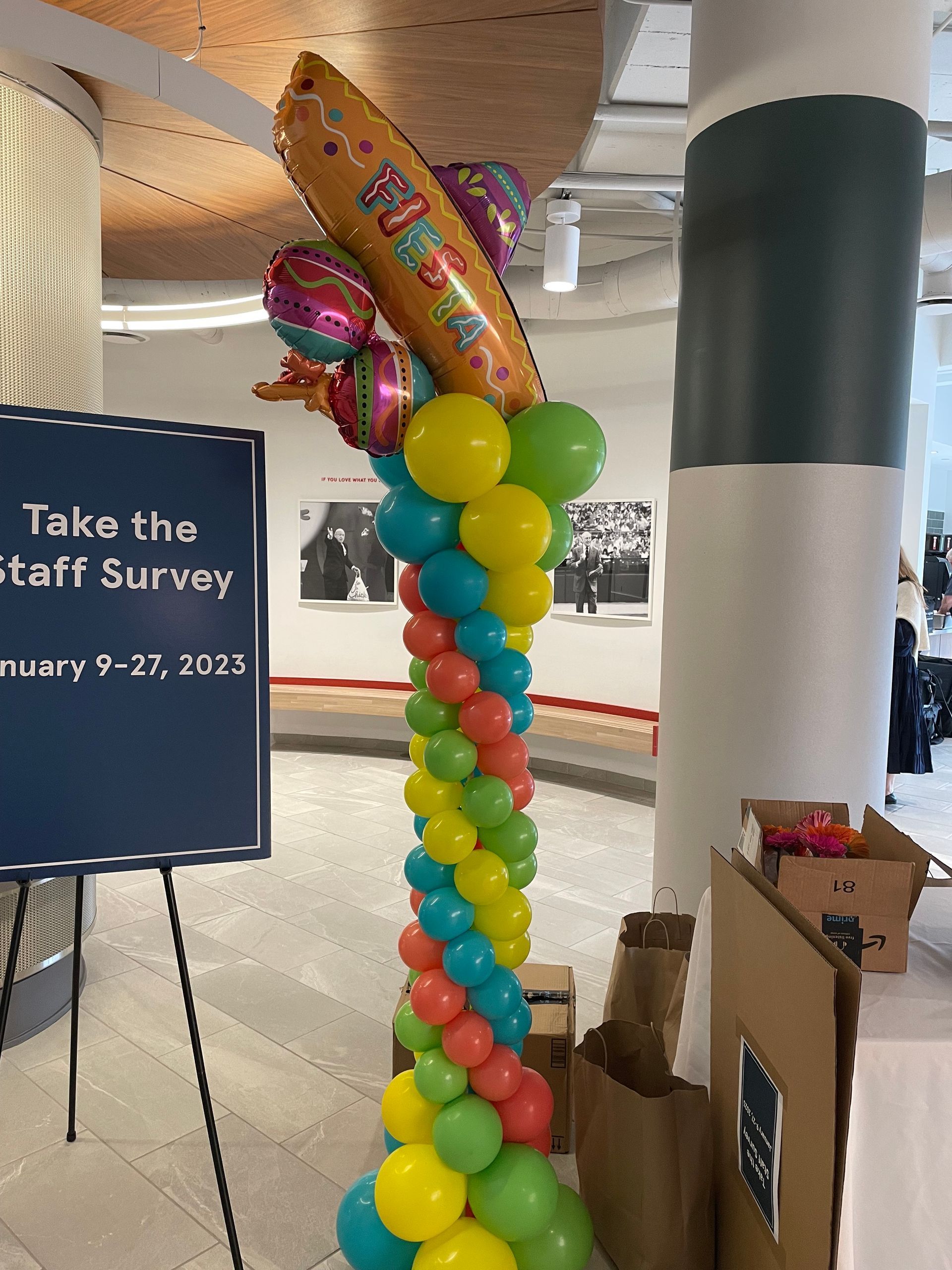 Colorful balloon column with fiesta-themed foil balloon topper inside an event venue