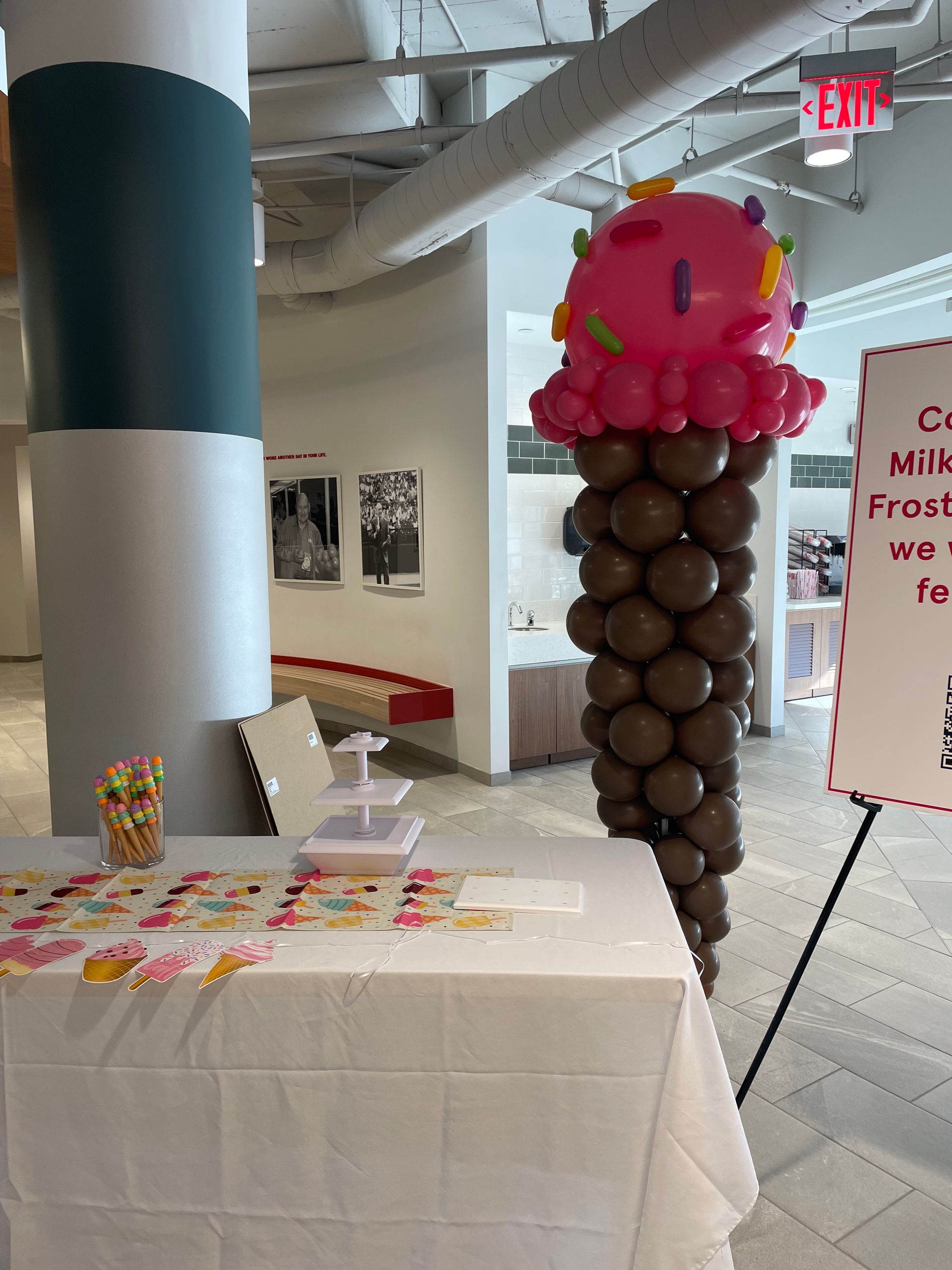 Ice cream–themed balloon sculpture with pink scoop design inside an event space