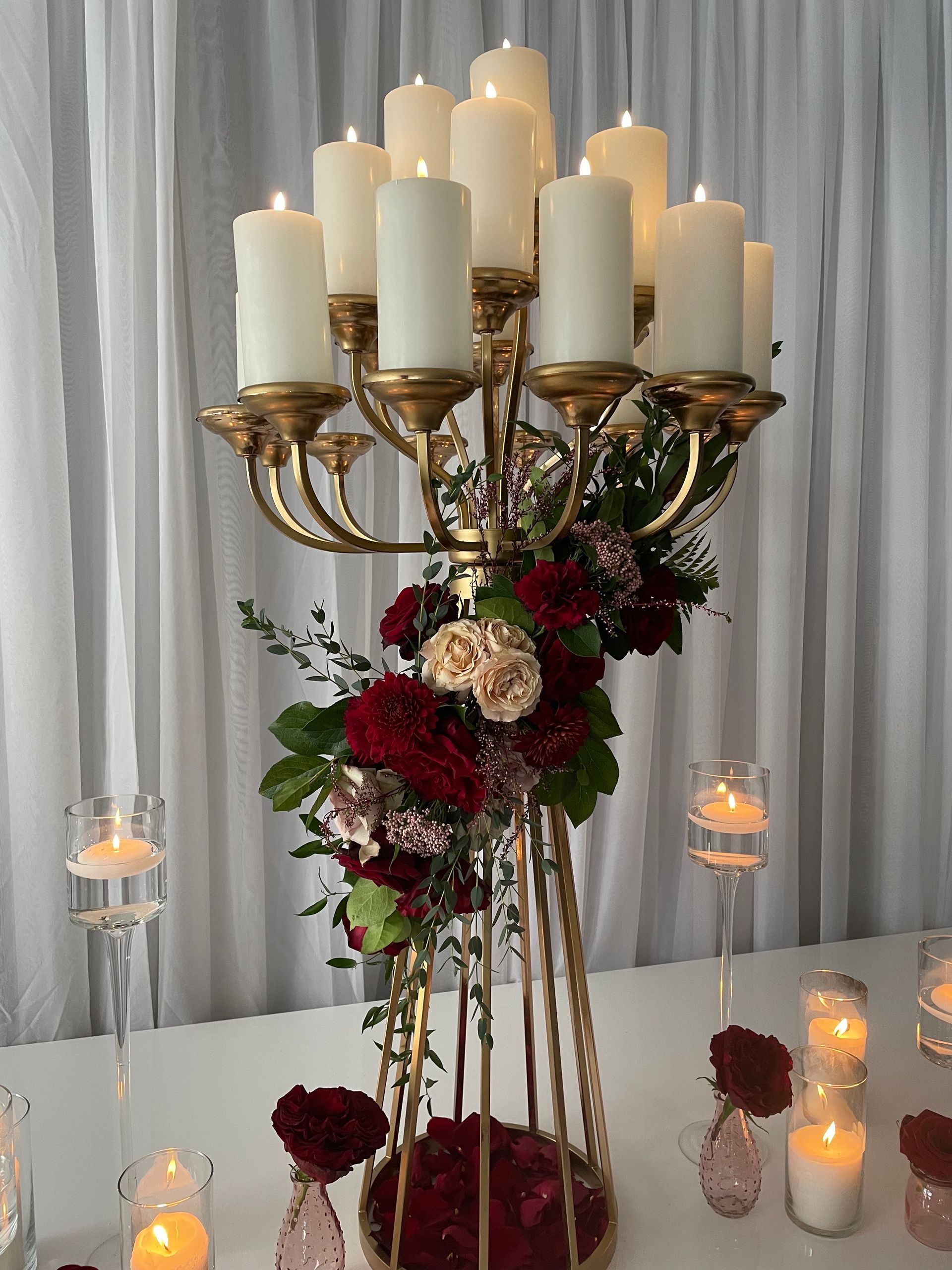 Gold candelabra centerpiece with multiple white pillar candles for an elegant tablescape