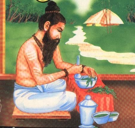 Seated bearded man mixing herbs in a bowl, with teapot and cups on a table in a green outdoor setting at Enlightened Life Temple