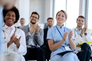 Audience applauding at a business presentation in a bright conference room