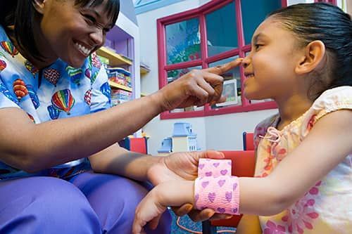 Smiling caregiver and child sharing a playful moment in a colorful room