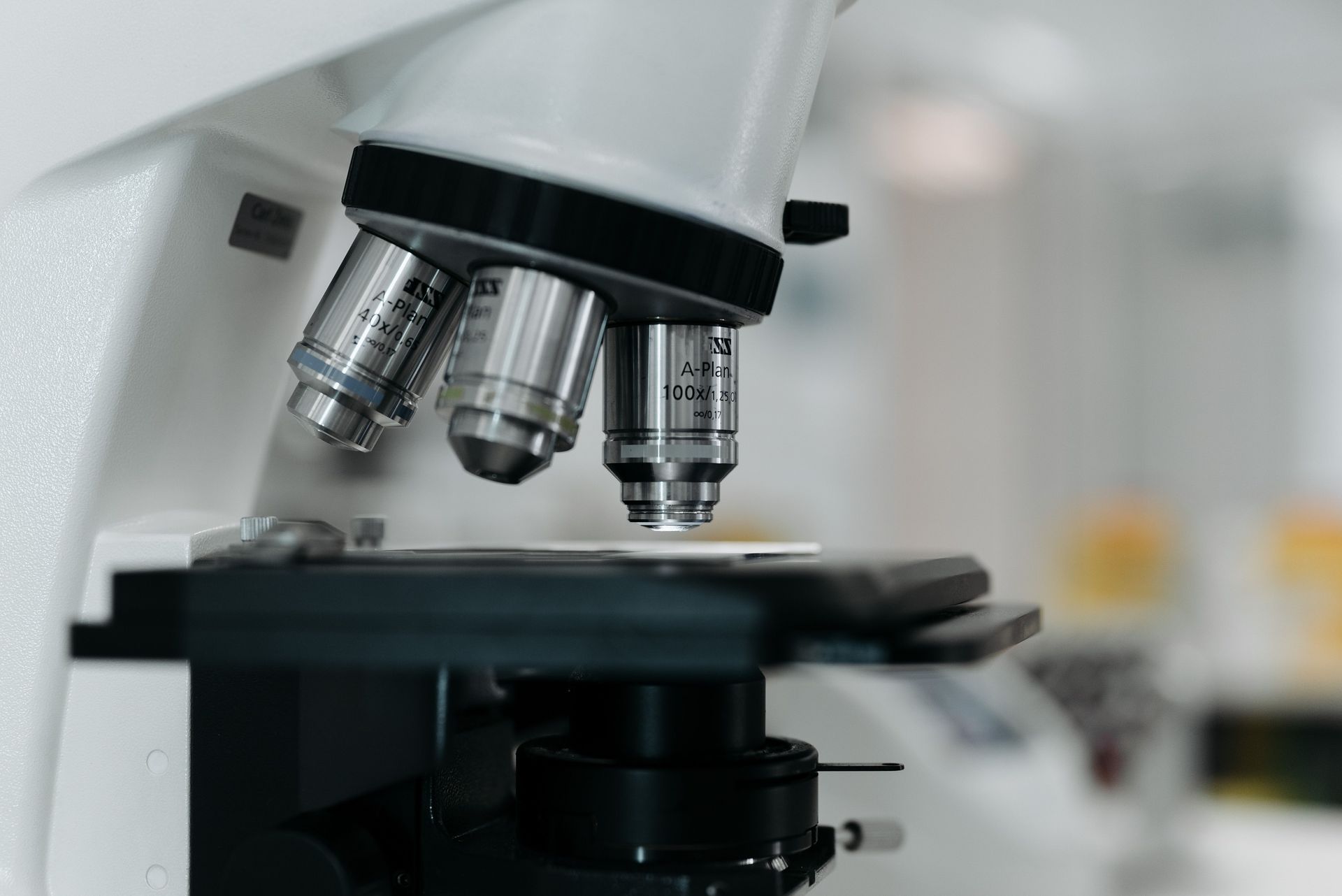 Close-up of a microscope with multiple objective lenses over a lab slide