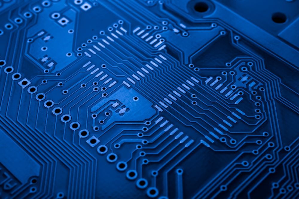 Blue circuit board with intricate pathways and components.