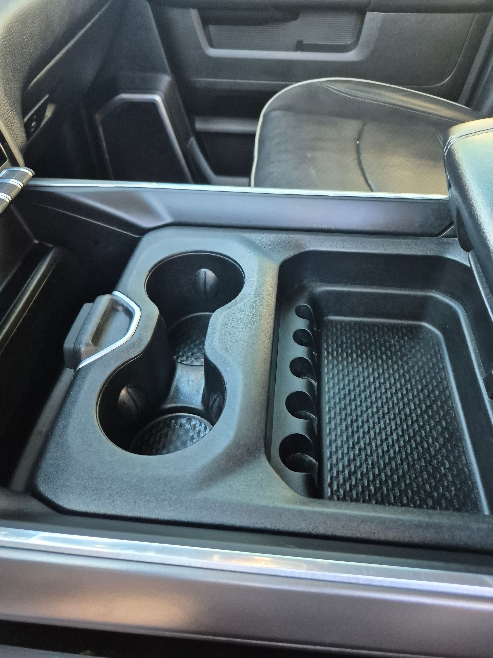Car center console tray with cupholders and a textured storage compartment