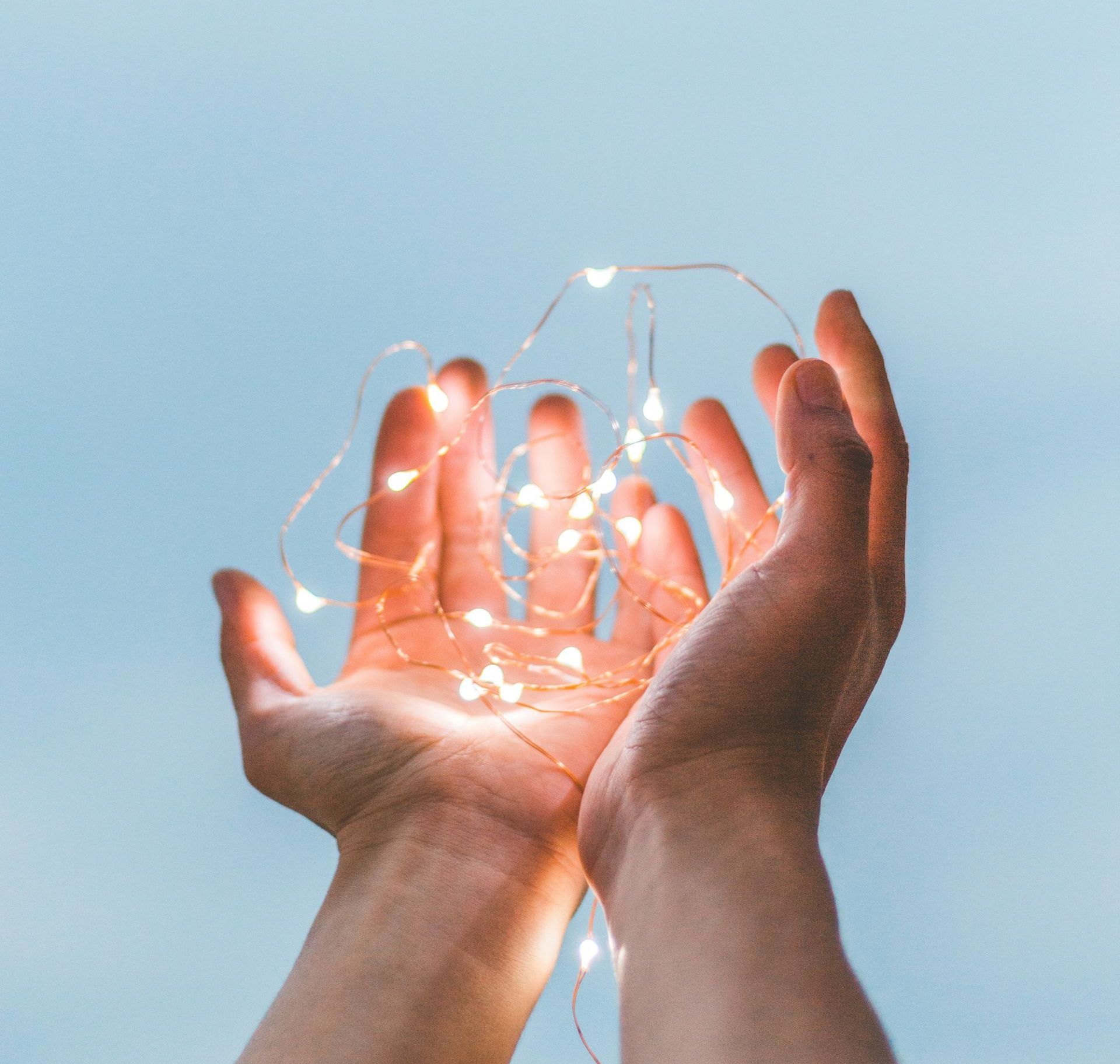 A person is holding a string of lights in their hands