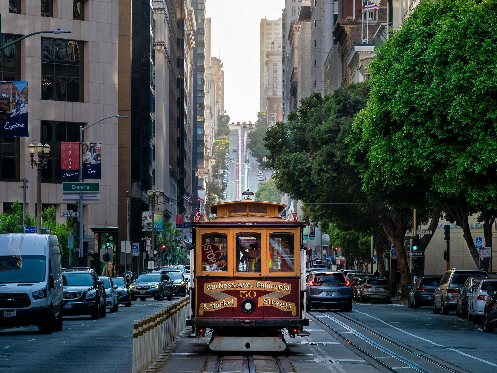 A cable car is going down a city street in San Francisco