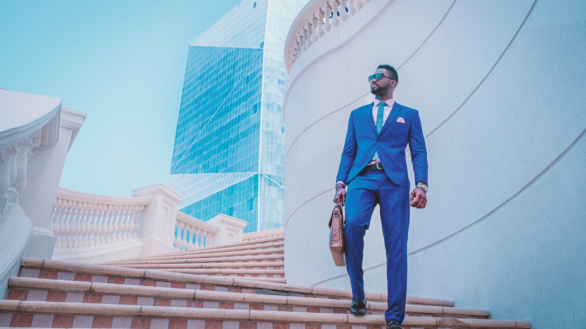 Man in a blue suit walking down a set of stairs