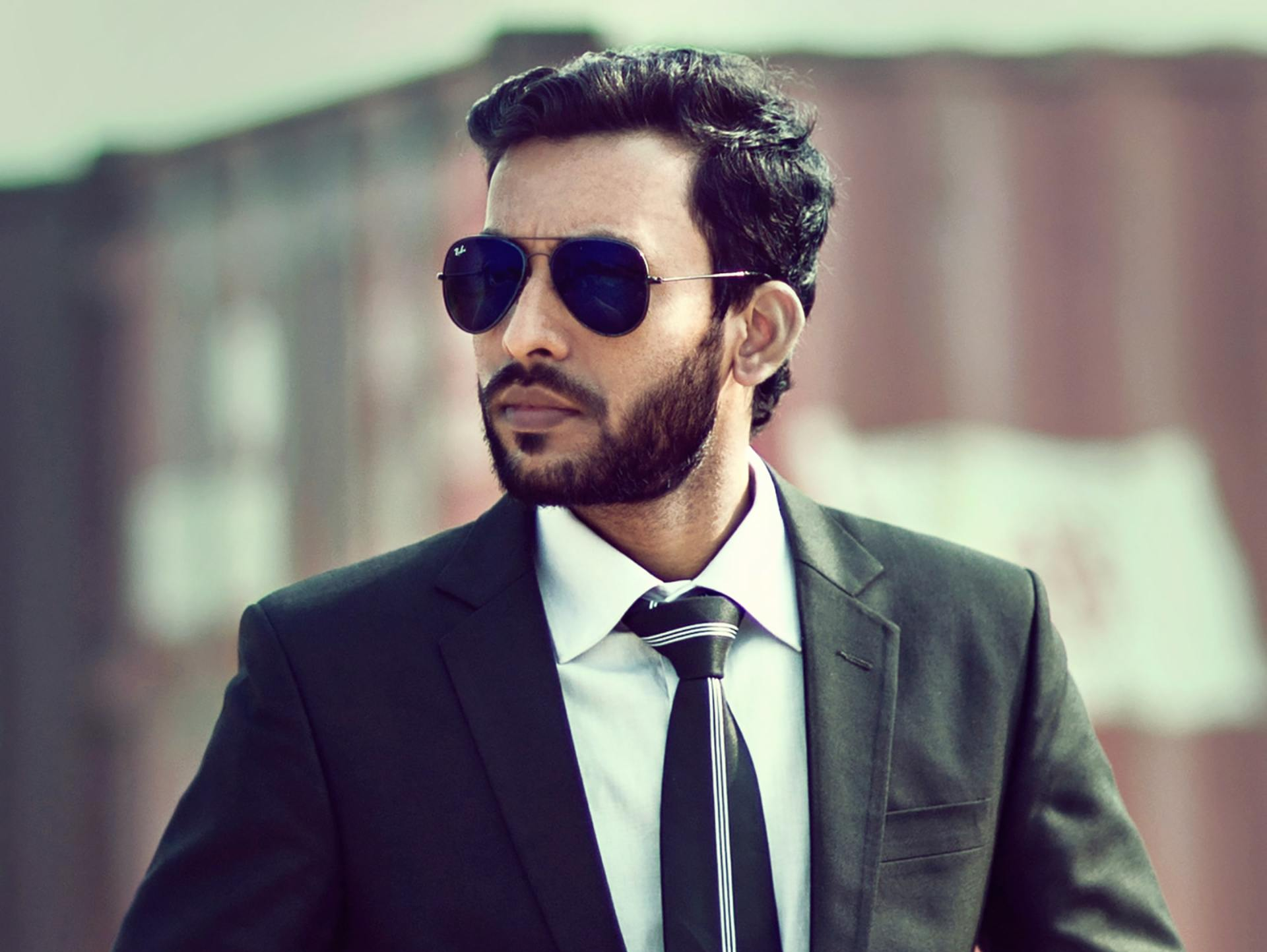Man in a suit and tie wearing sunglasses.