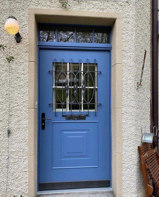 blaue Haustüre an grauem Haus