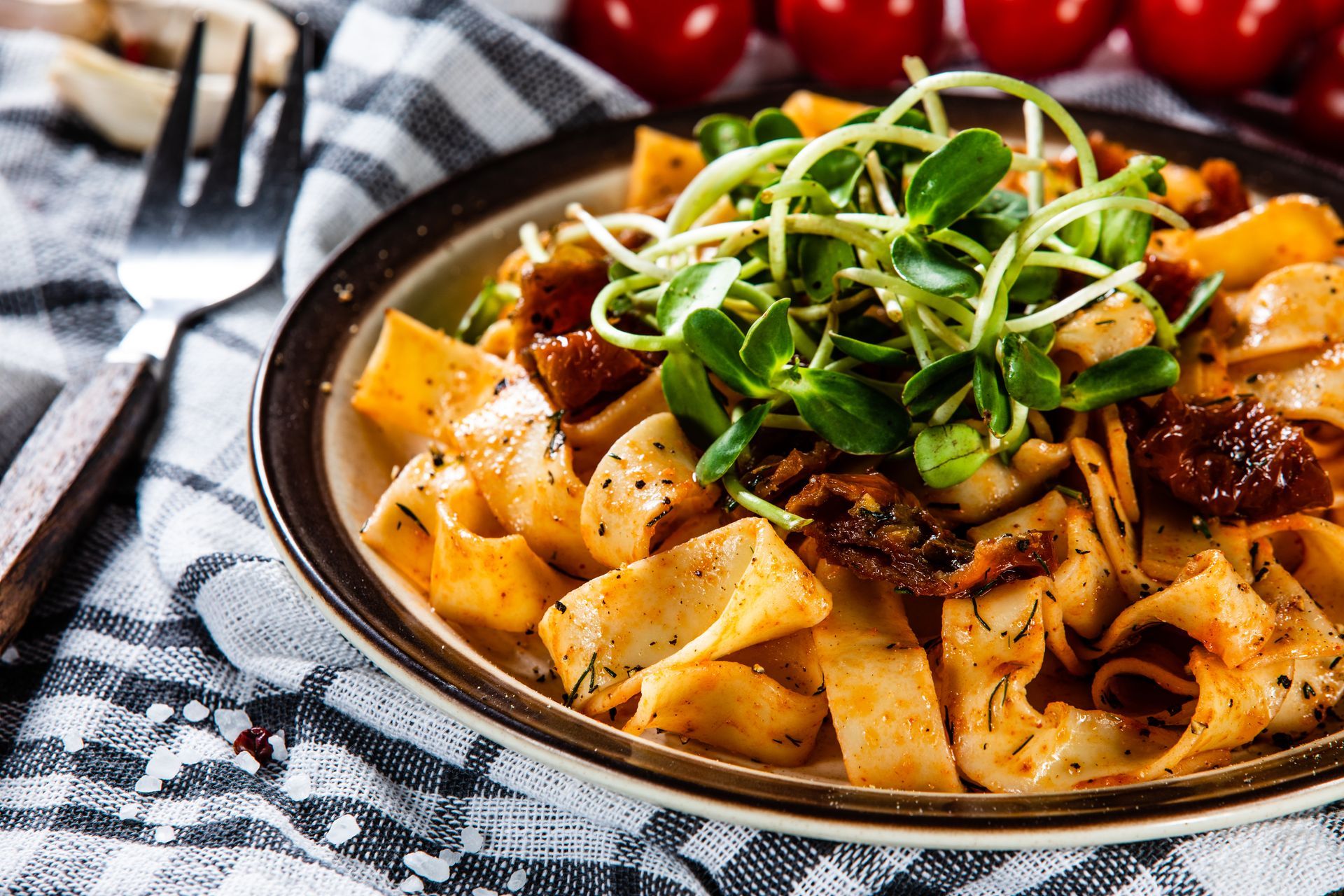 A Plate of Pasta With Tomatoes and Sprouts on a Table With a Fork — Mumbo's Pizza'n'Pasta In Lismore, NSW