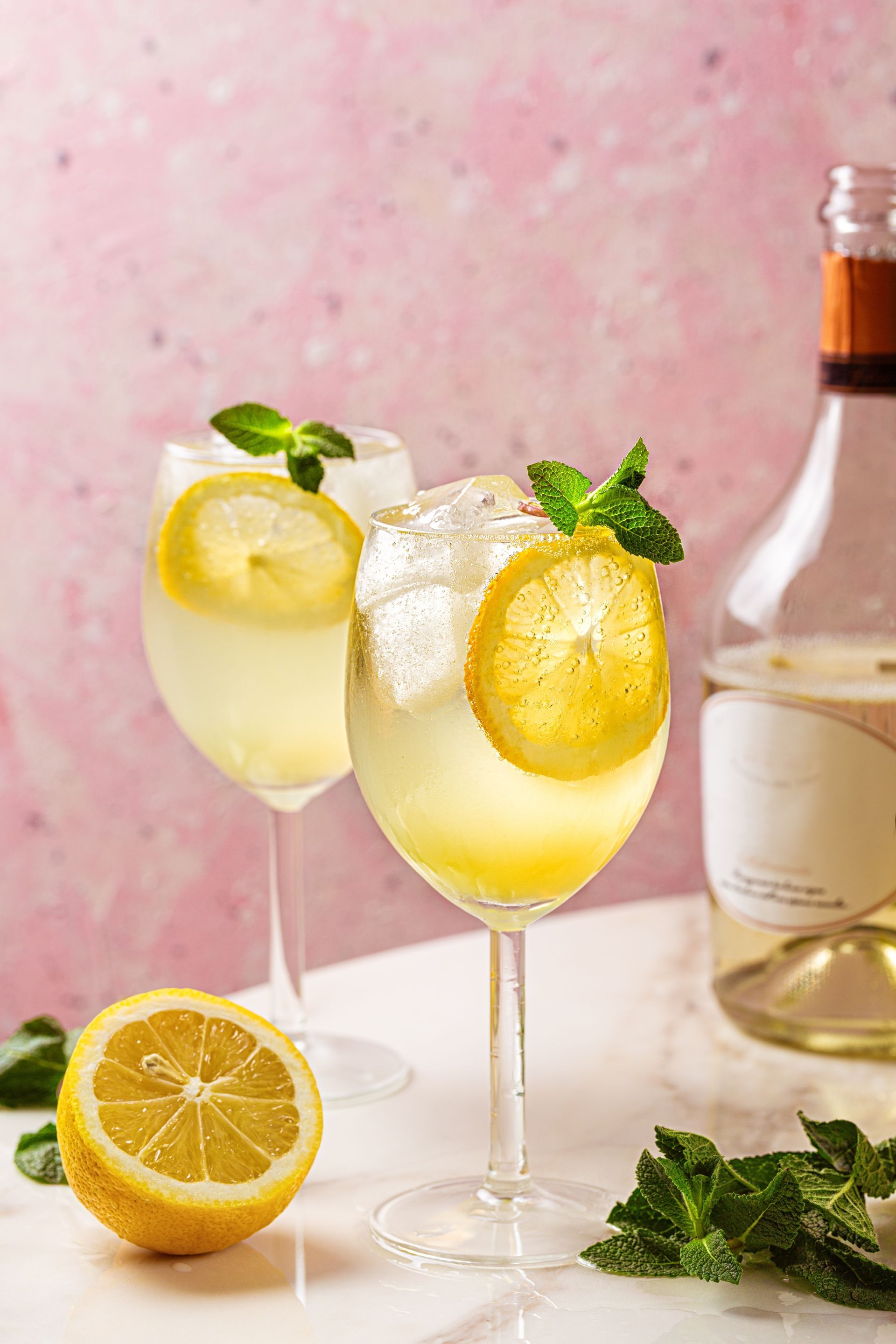 Two Glasses of Wine With Lemon Slices and a Bottle of Wine on a Table — Mumbo's Pizza'n'Pasta In Lismore, NSW