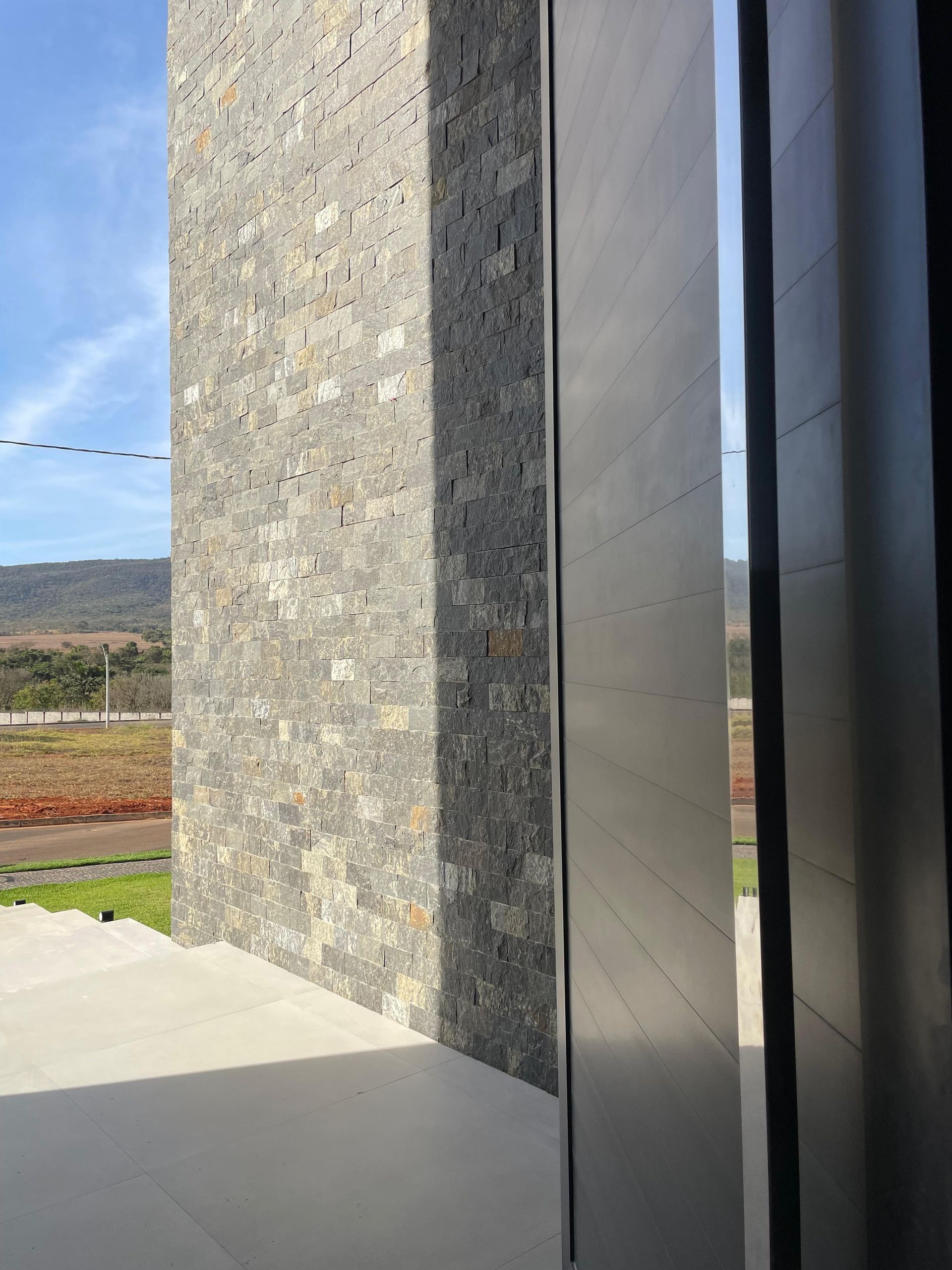 bossa nero, pedra bossa nero, bossa nero revestimento, revestimento grafite, pedra para fachada escura, revestimento natural preto, pedra para parede rockface, revestimento contemporâneo escuro, pedra natural para volume de fachada, pedra escura com pastilha, revestimento para muro grafite