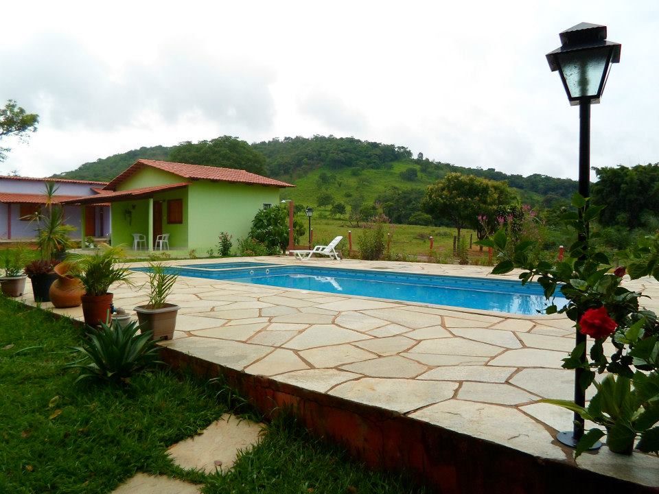 Pedra Lajão natural aplicada em pisos e caminhos externos, com grandes peças irregulares em tons de cinza, verde e bege integradas ao paisagismo tropical.