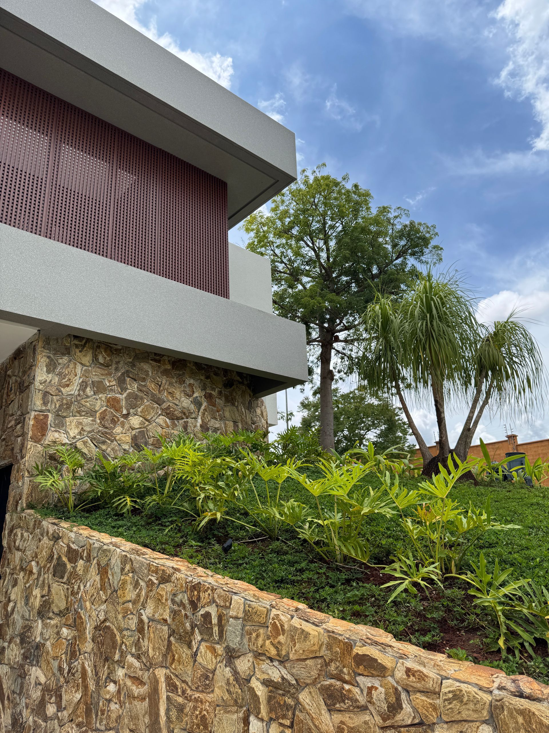 Pedra Amazon natural aplicada em fachadas, paredes e ambientes internos, com variações de tons terrosos, dourados e acinzentados.