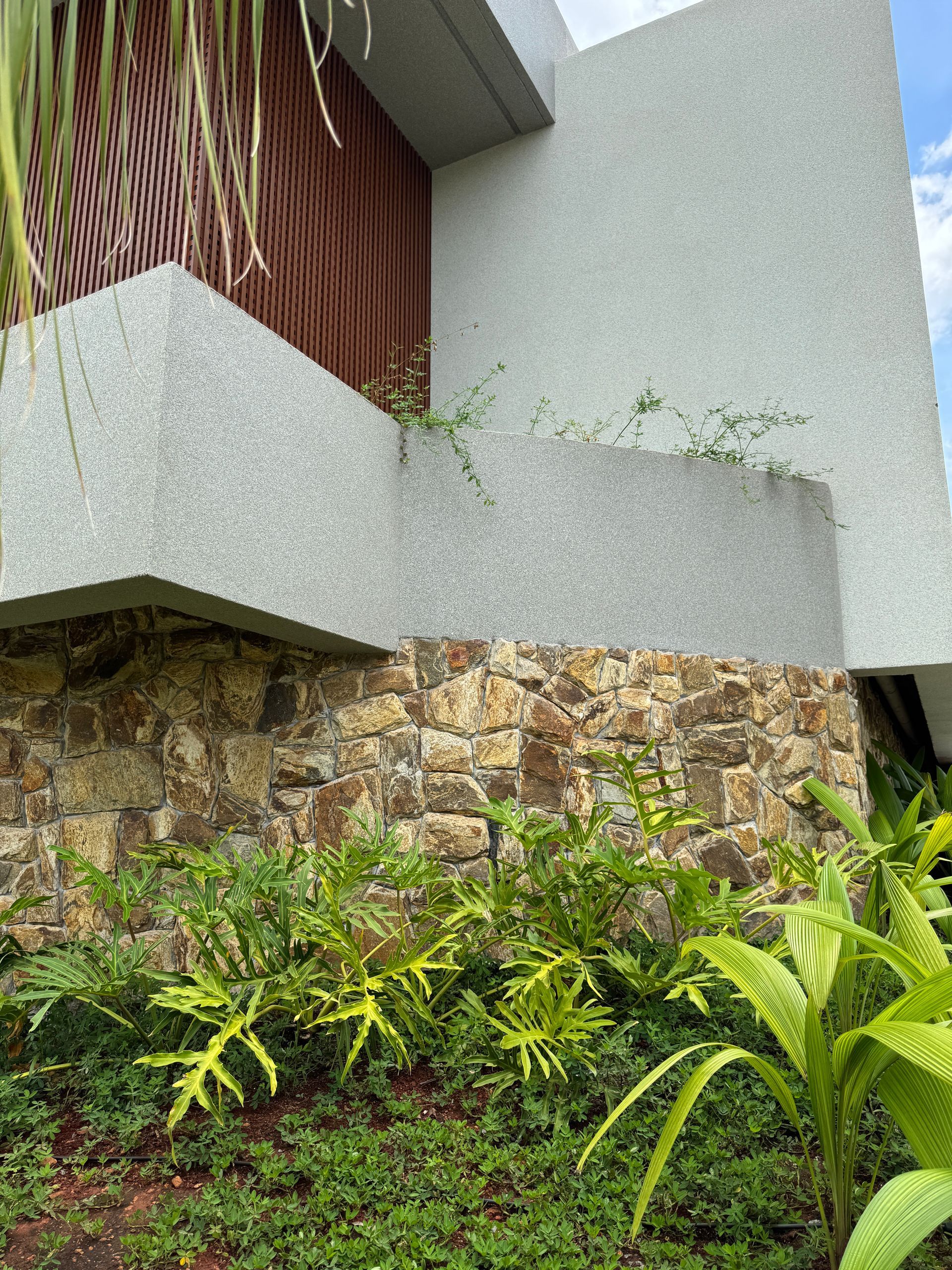 Pedra Amazon natural aplicada em fachadas, paredes e ambientes internos, com variações de tons terrosos, dourados e acinzentados.