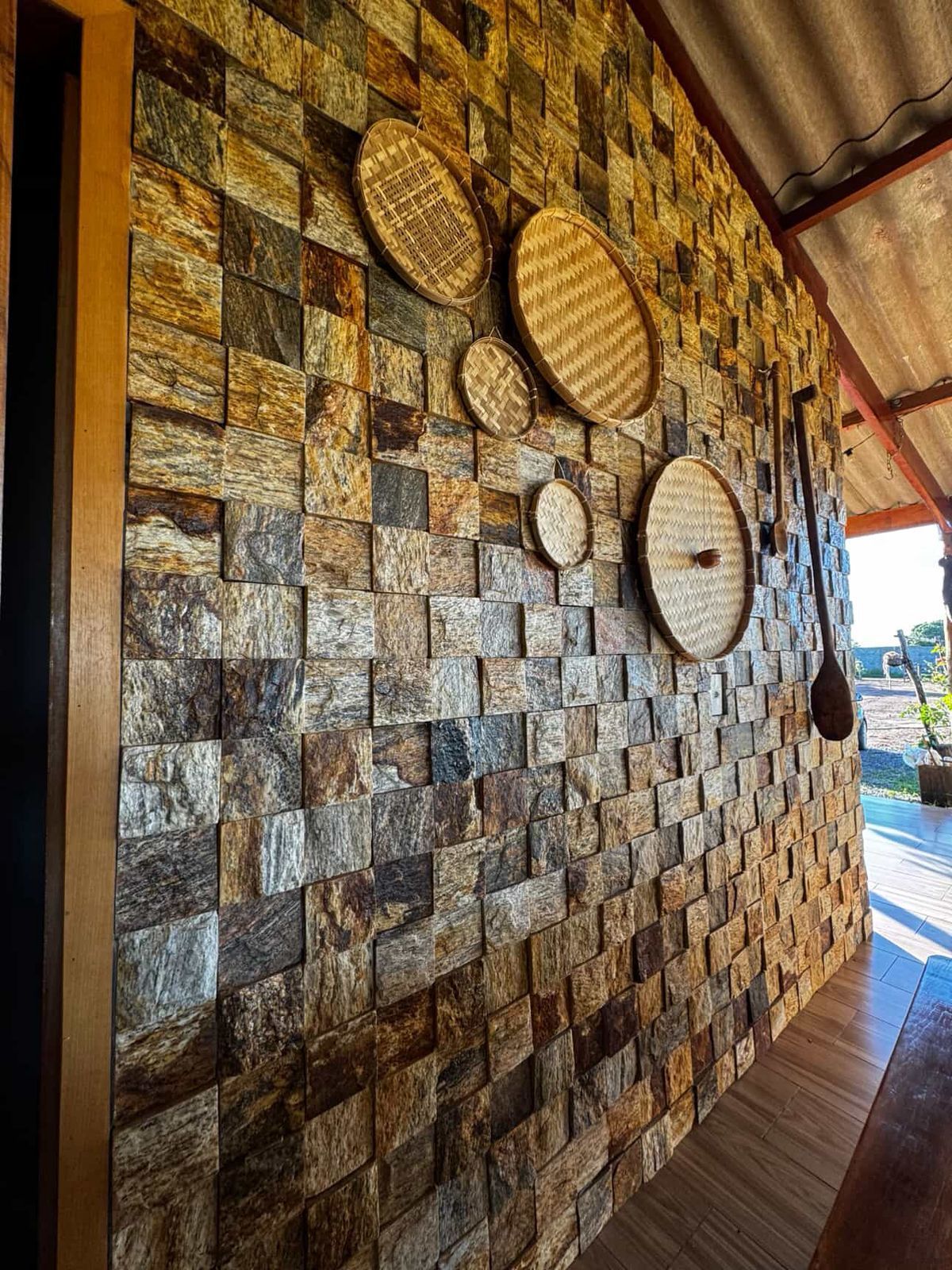 Pedra Amazon natural aplicada em fachadas, paredes e ambientes internos, com variações de tons terrosos, dourados e acinzentados.