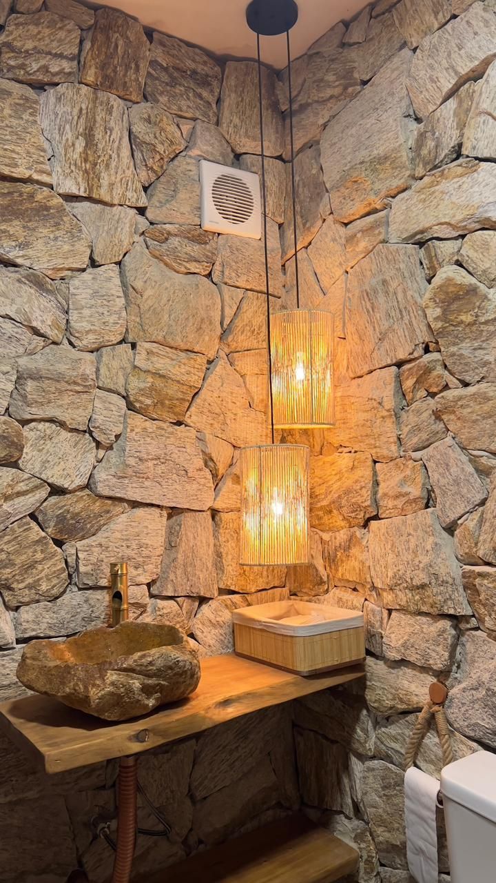 Pedra Amazon natural aplicada em fachadas, paredes e ambientes internos, com variações de tons terrosos, dourados e acinzentados.