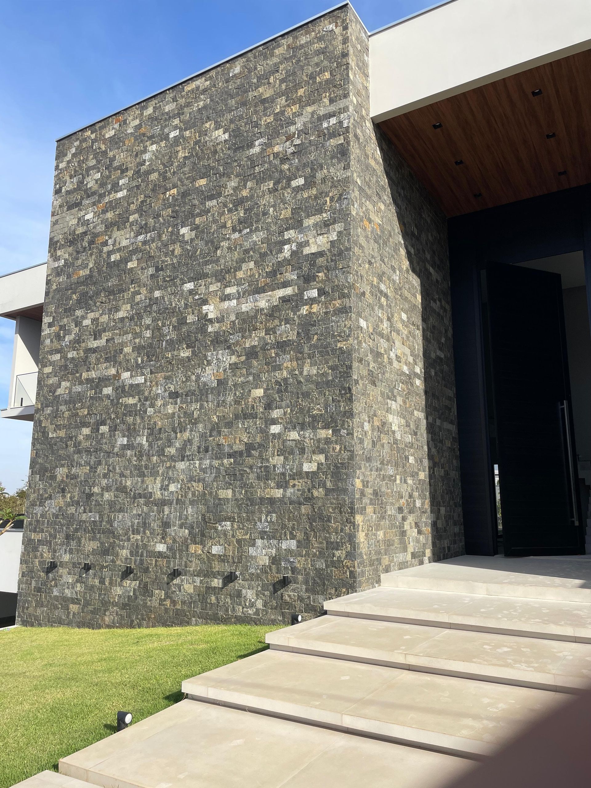 bossa nero, pedra bossa nero, bossa nero revestimento, revestimento grafite, pedra para fachada escura, revestimento natural preto, pedra para parede rockface, revestimento contemporâneo escuro, pedra natural para volume de fachada, pedra escura com pastilha, revestimento para muro grafite