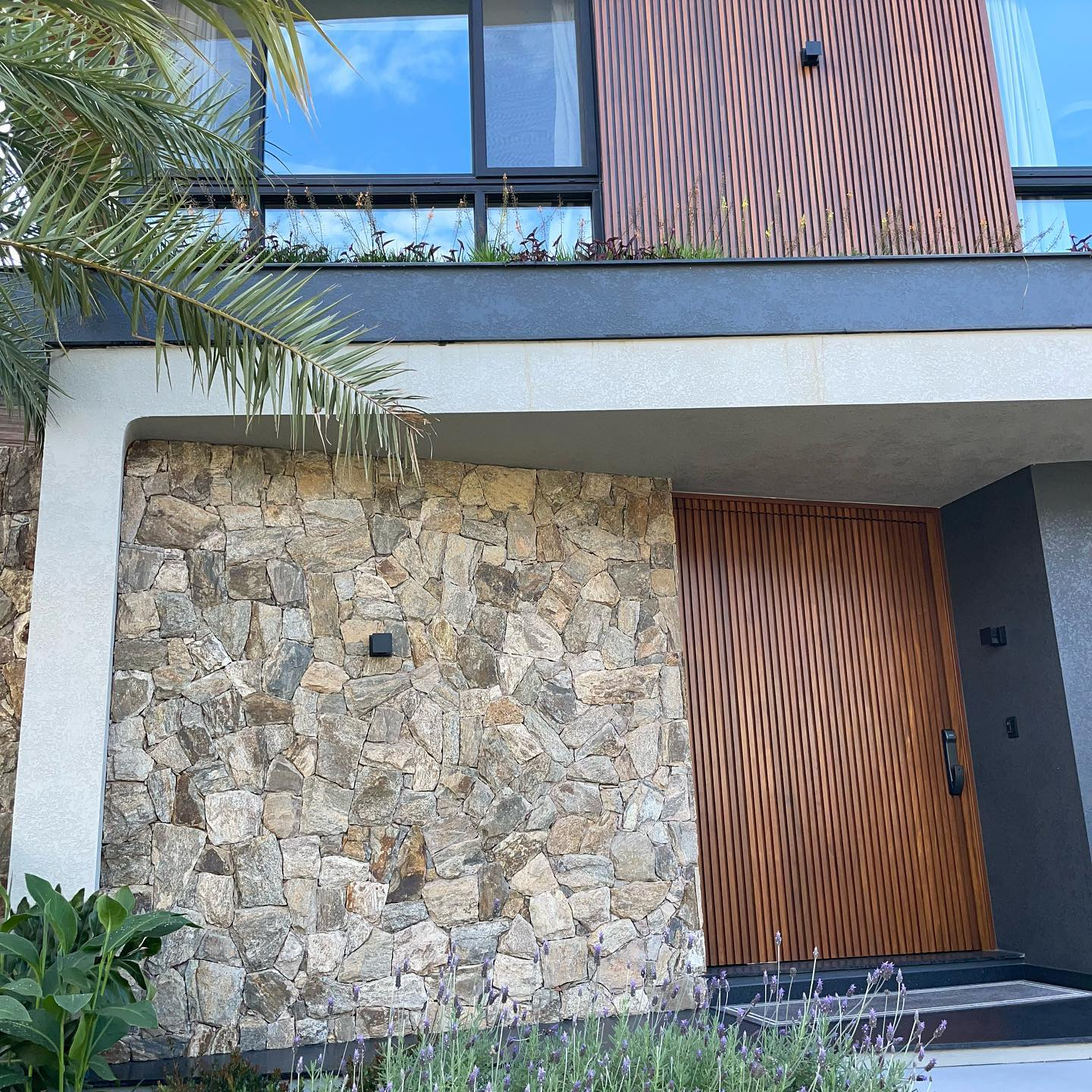 Pedra Amazon natural aplicada em fachadas, paredes e ambientes internos, com variações de tons terrosos, dourados e acinzentados.