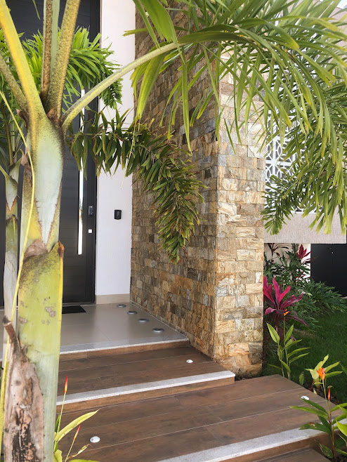 Pedra Amazon natural aplicada em fachadas, paredes e ambientes internos, com variações de tons terrosos, dourados e acinzentados.