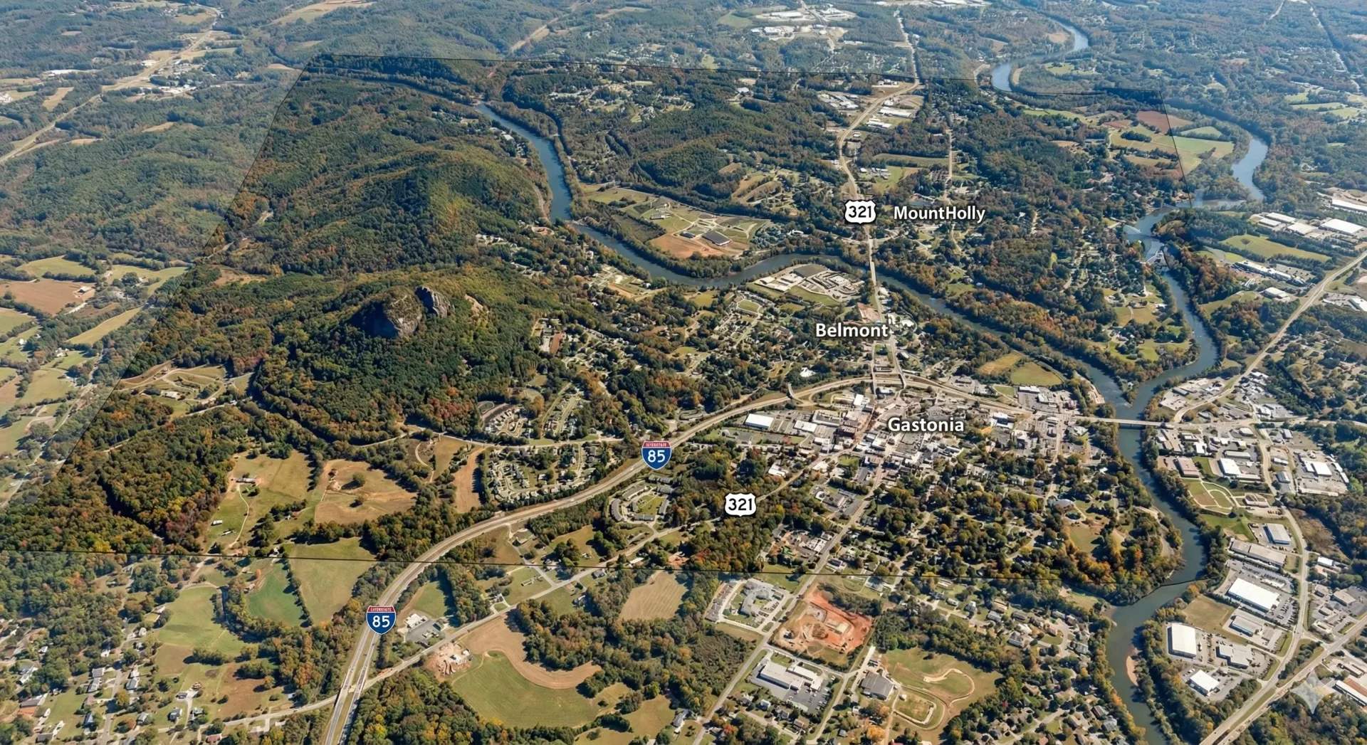 An aerial view of a highway intersection with a city in the background.