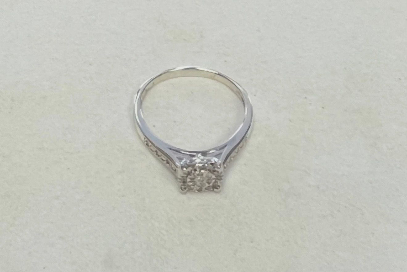 Silver ring with a square diamond cluster on a light background
