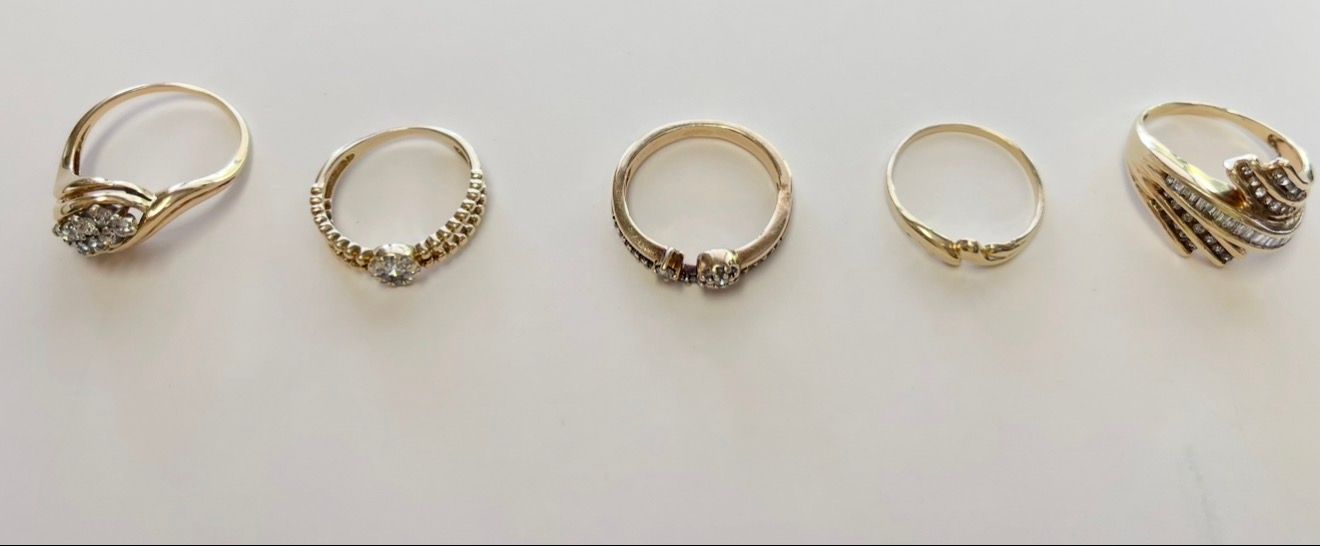 Five gold rings arranged in a row on a light background