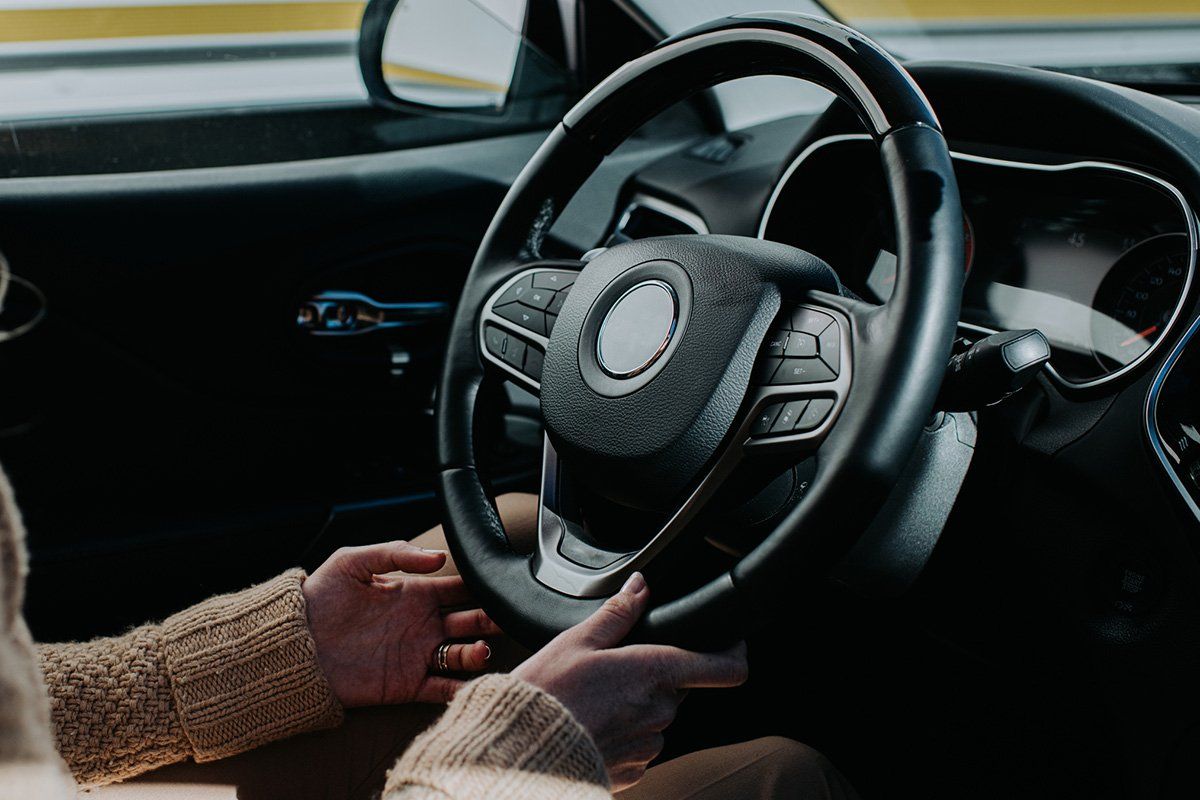 Female Hands Holding Steering Wheel in a Car — Central Islip, NY — Defensive Driving School Female Hands Holding Steering Wheel in a Car — Central Islip, NY — Defensive Driving School