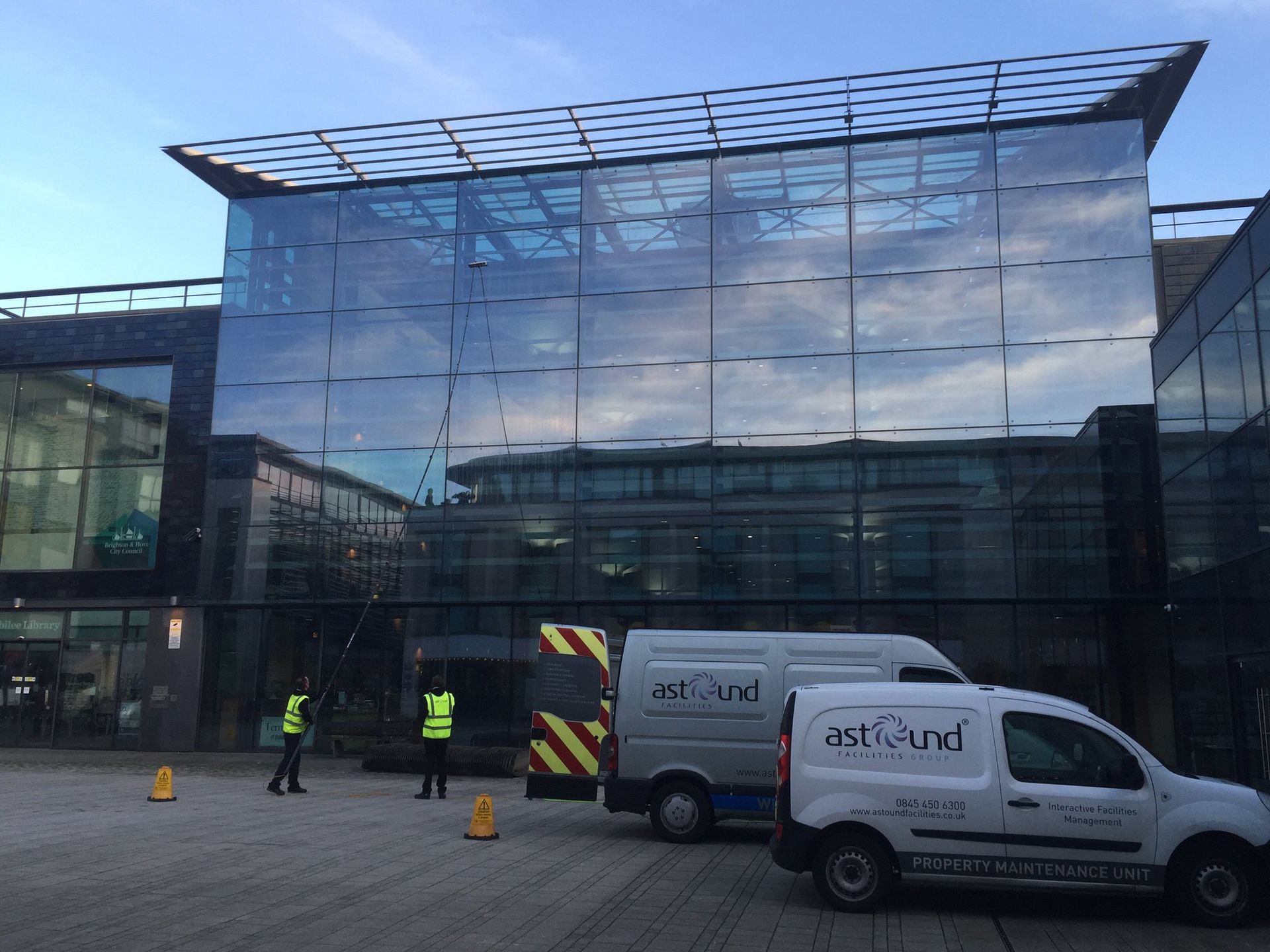 Two Man using telescopic pole with pure water doing commercial window cleaning