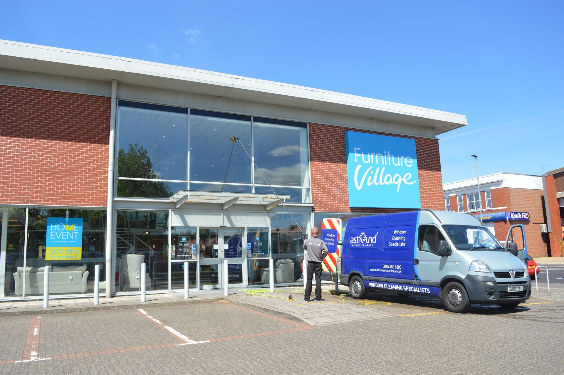 Astound Cleaning van and operator demonstrating what is commercial window cleaning using pure water reach and wash equipment on a shop front