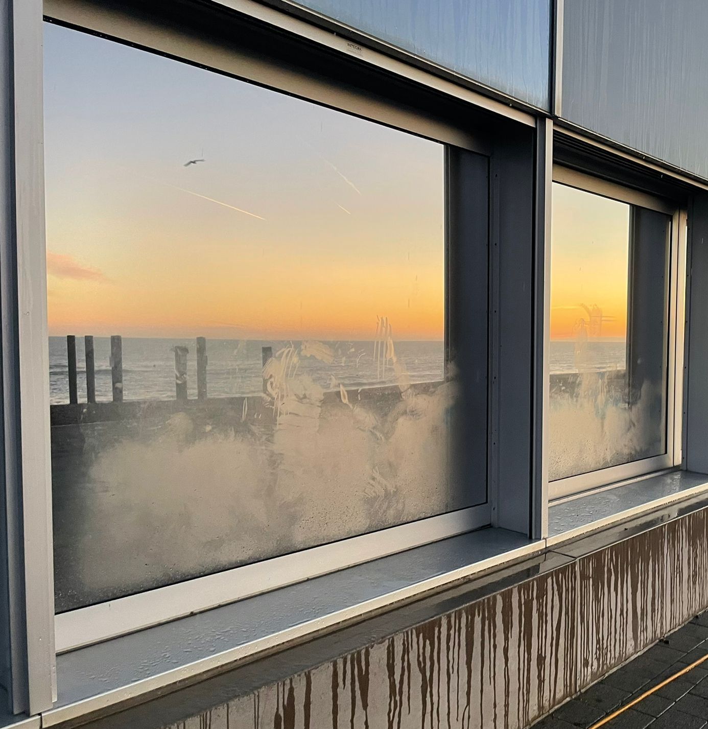 Water marked dirty window before being cleaned by a window cleaner near me on Brighton seafront
