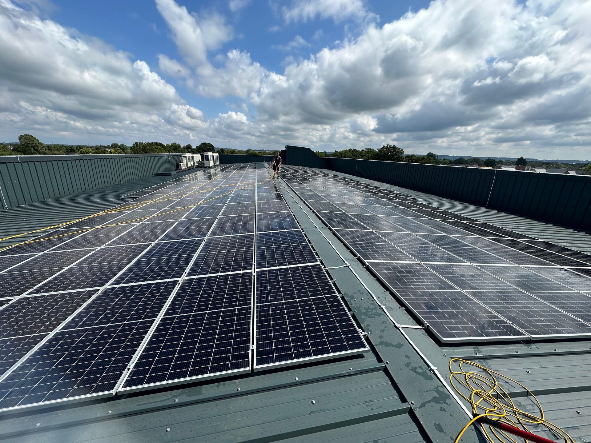 Solar panels on a flat commercial roof on a cloudy day.