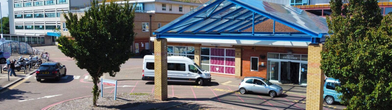 Worthing Hospital main entrance with blue covered drop-off area showing the NHS facility where Astou