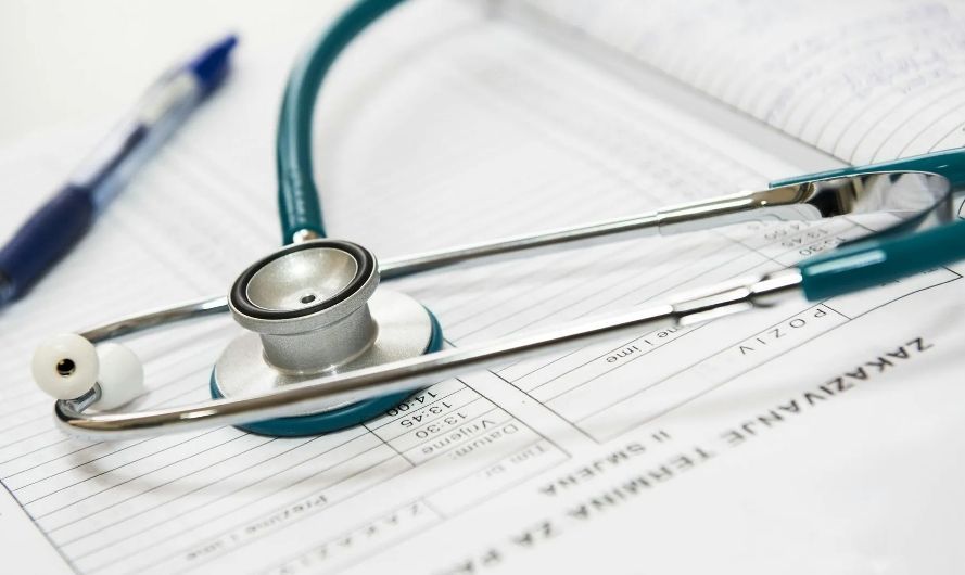 Stethoscope resting on paperwork and a pen.