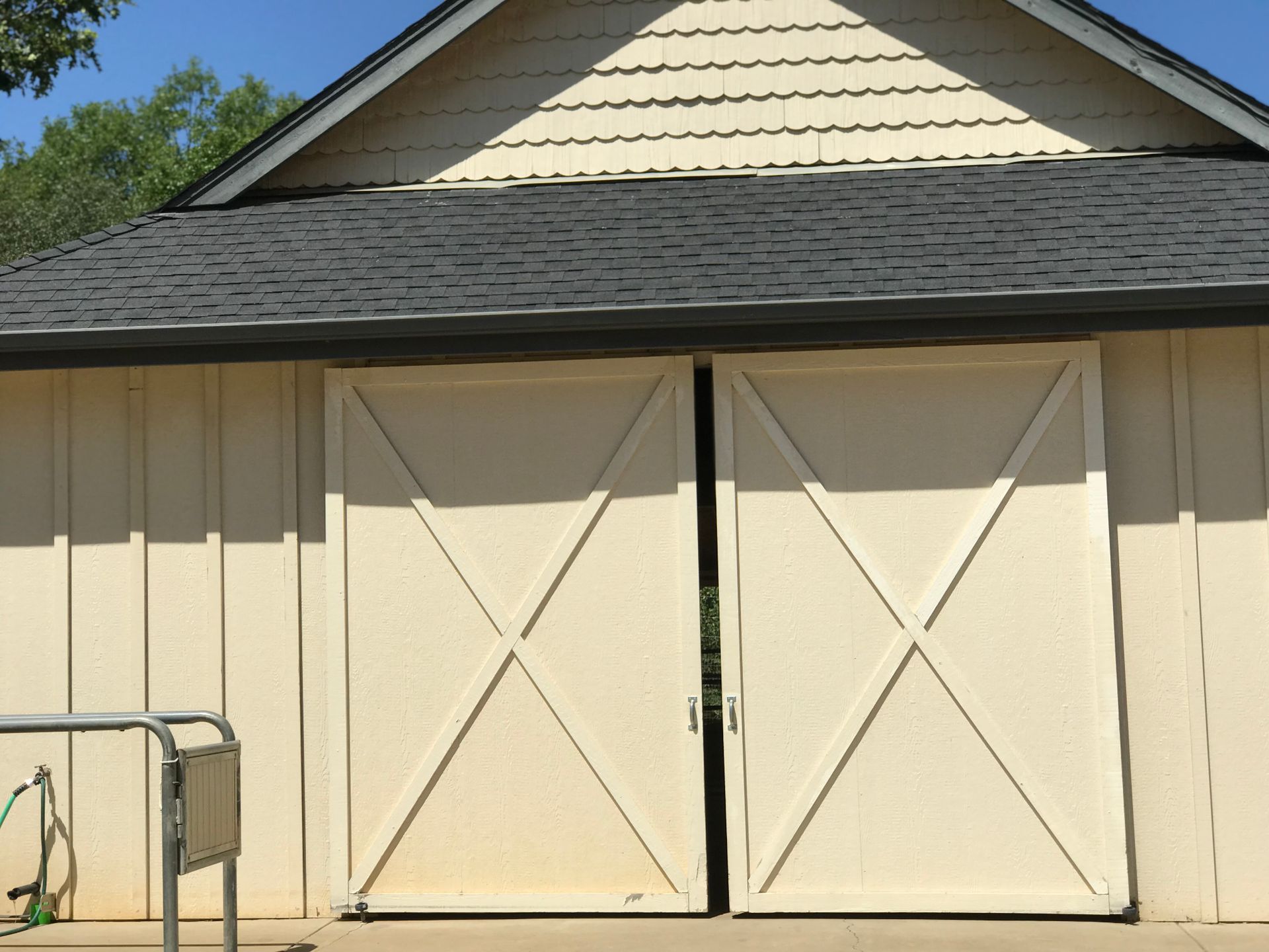 White Barn With Black Roof and Wood Doors
